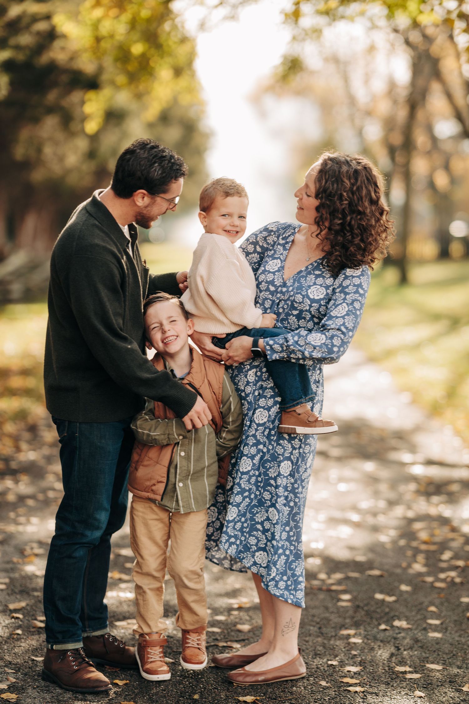 A sweet family moment captured in a series of candid photos on a fall day in a park setting.