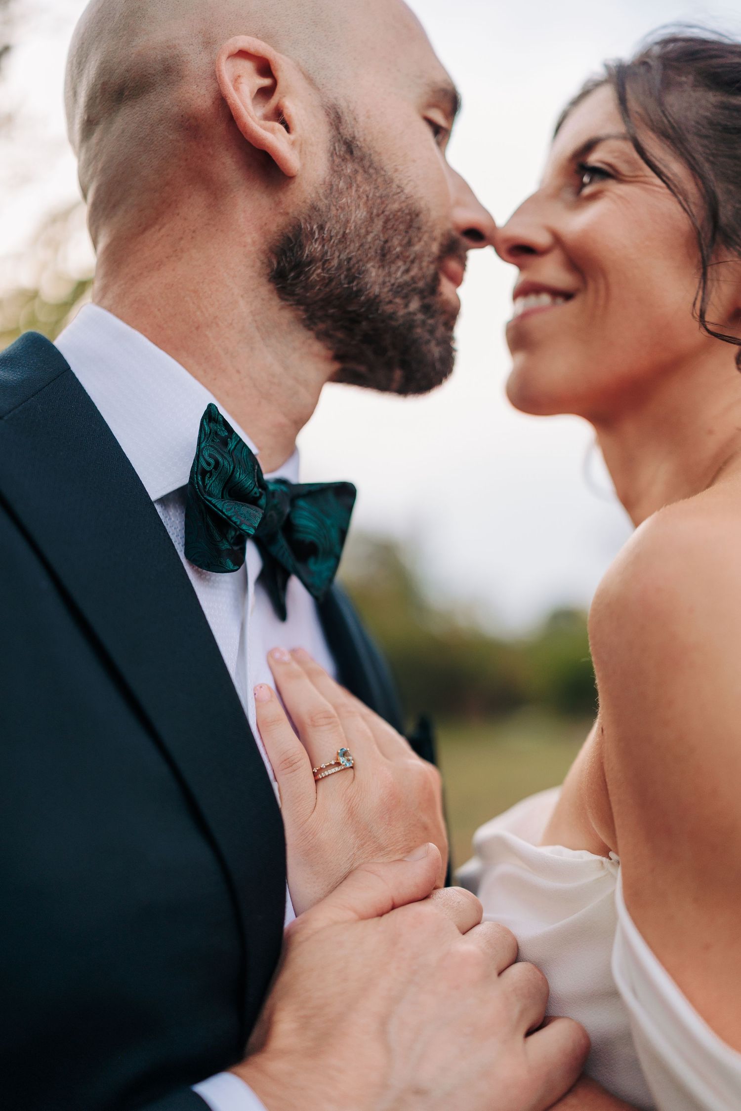 An intimate moment between newlyweds with the groom wearing a teal bowtie.