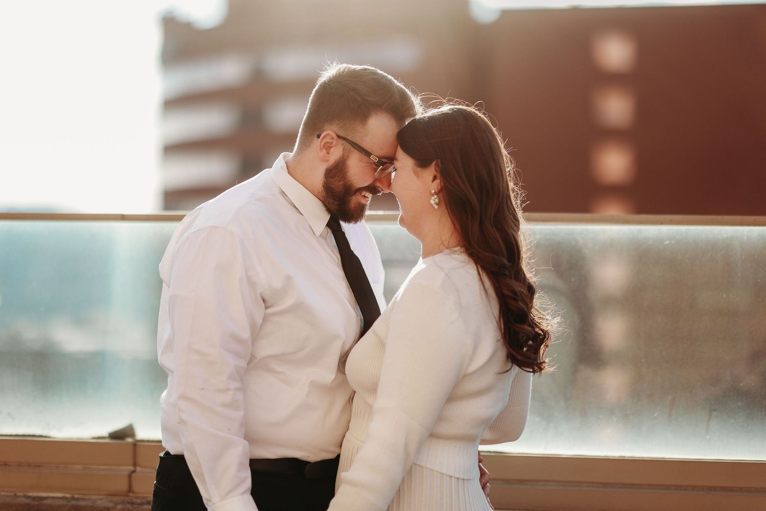 An intimate rooftop moment at sunset with urban backdrop.