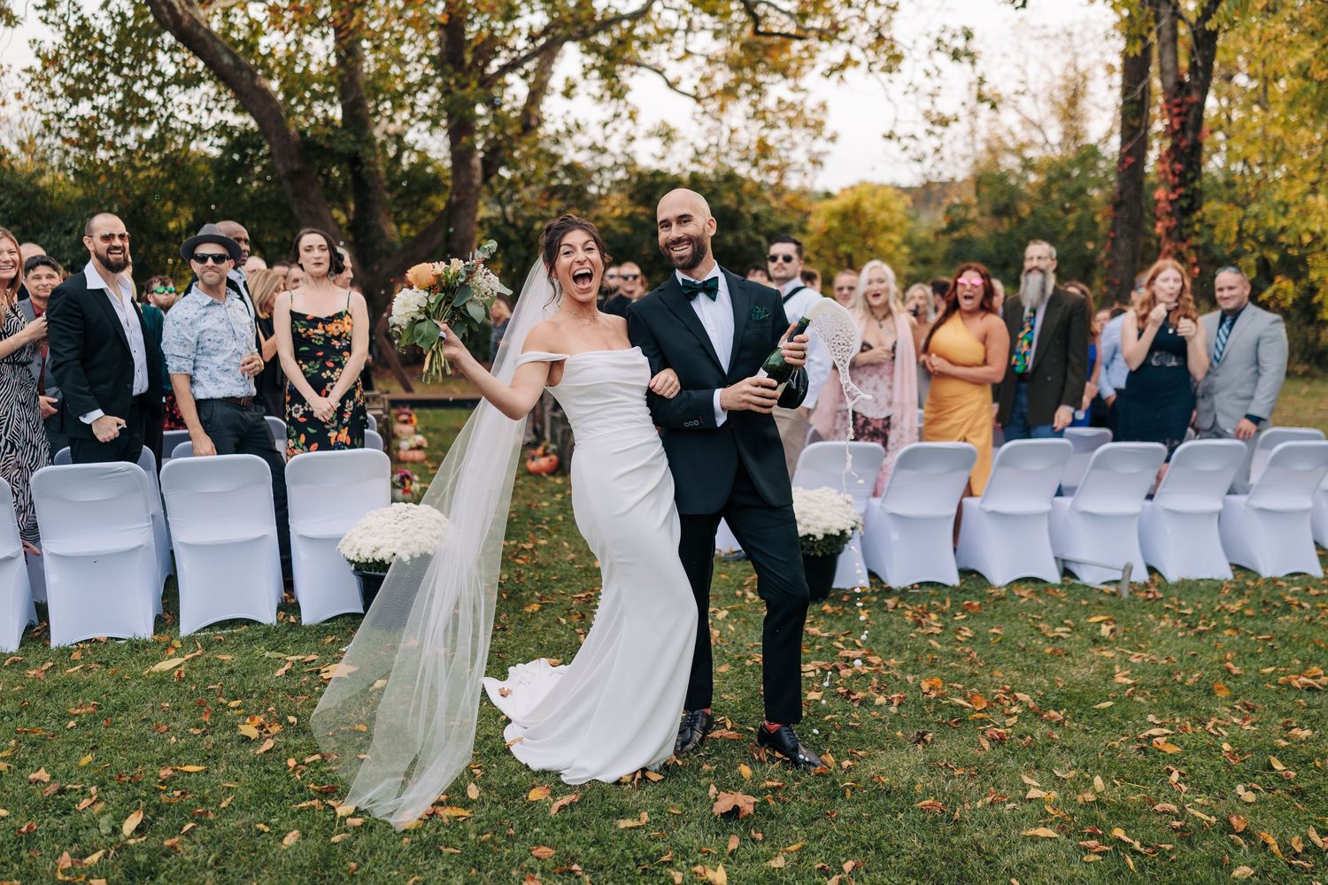 Outdoor wedding ceremony progression showing couple and guests on a grassy hillside with fall foliage.