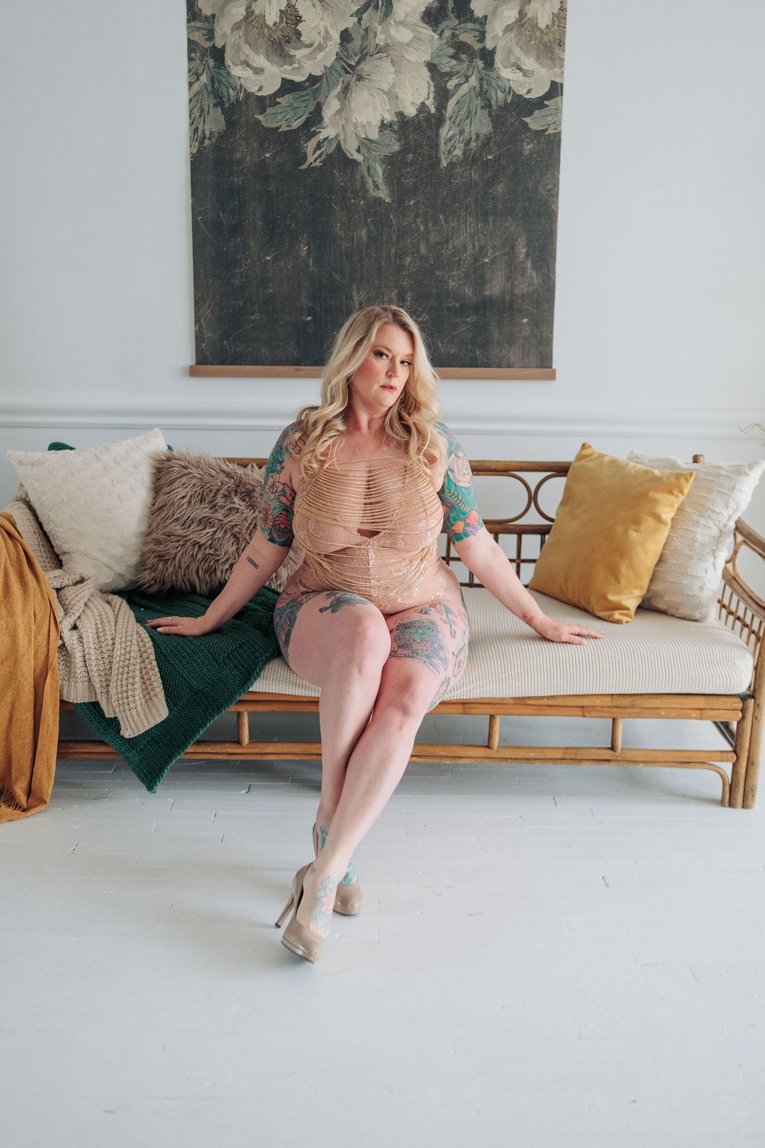 Person in pink loungewear relaxing on a modern sofa with yellow and brown throw pillows.