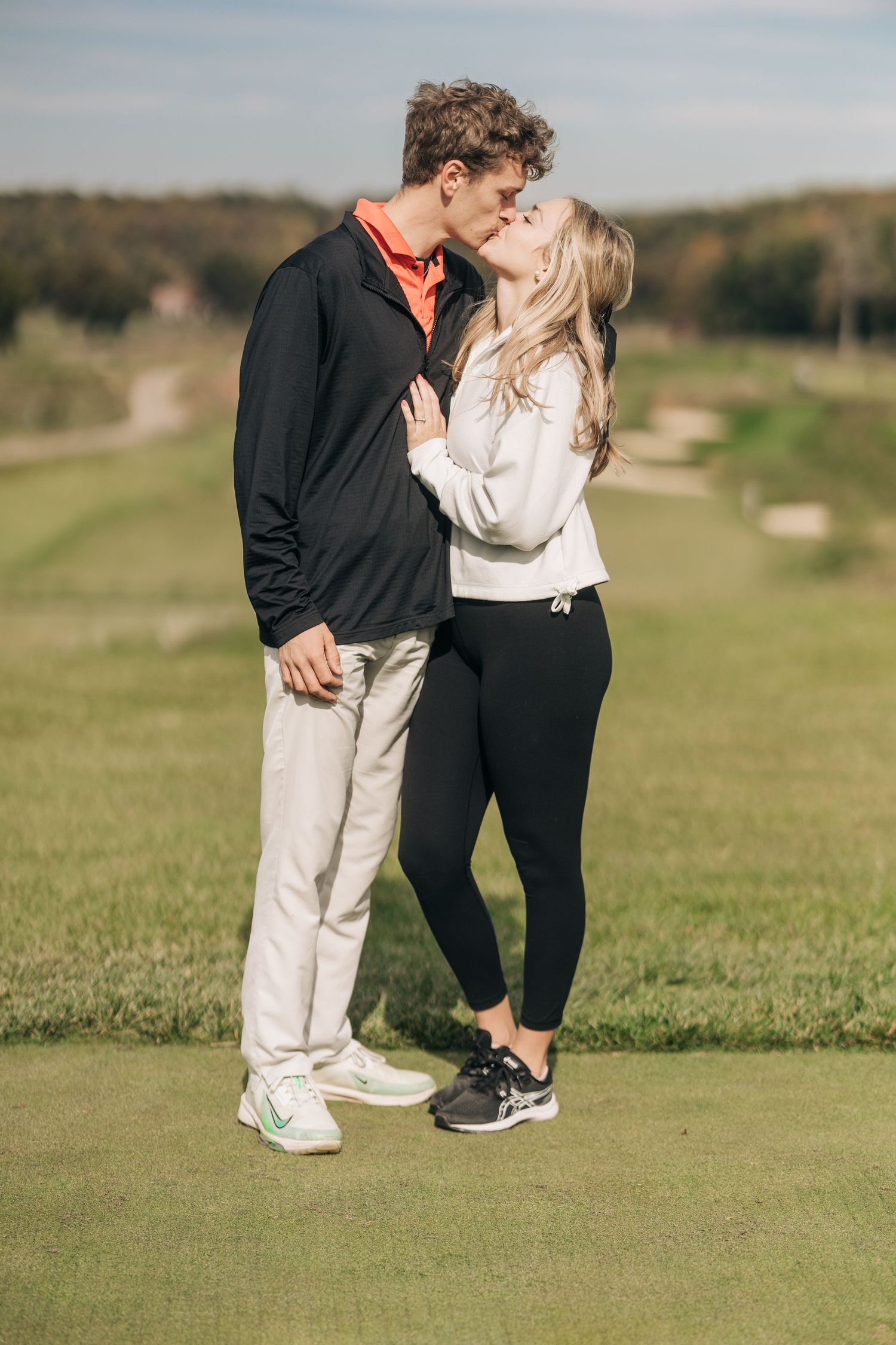A tender moment between a couple on a golf course green.