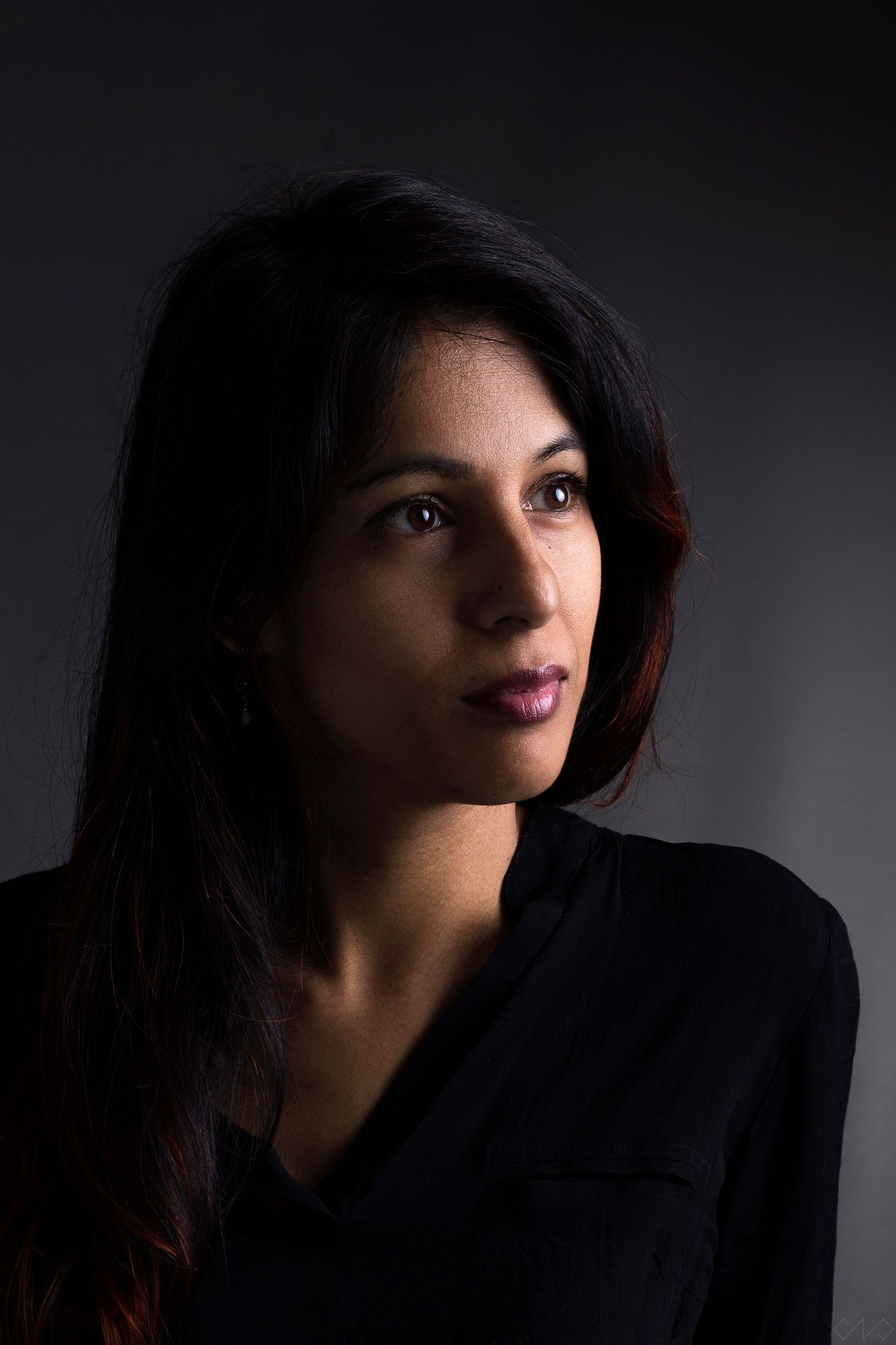 Portrait studio d'une femme brune de trois quart.