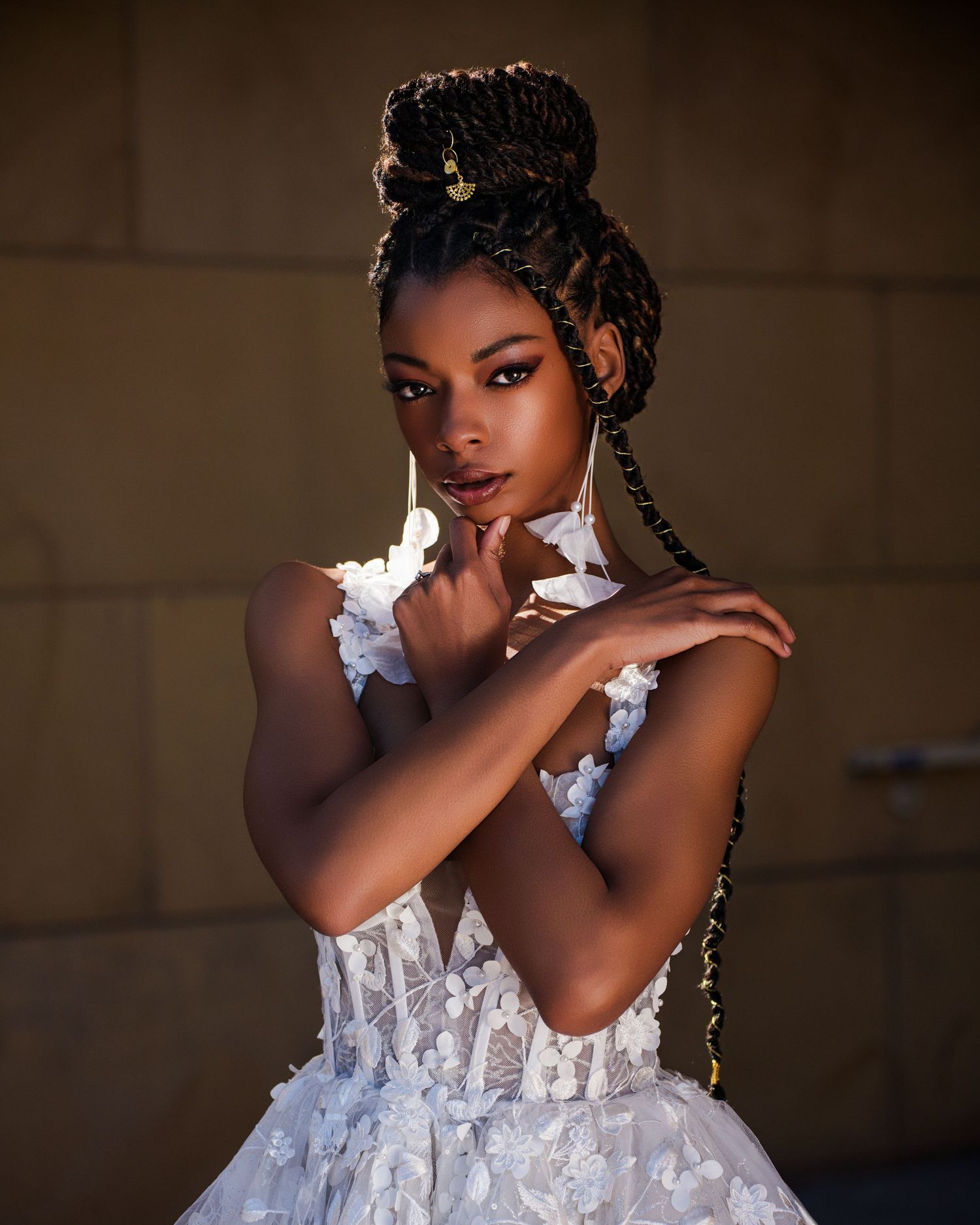Artistic bridal portrait in white lace dress with elegant updo hairstyle and dramatic lighting.