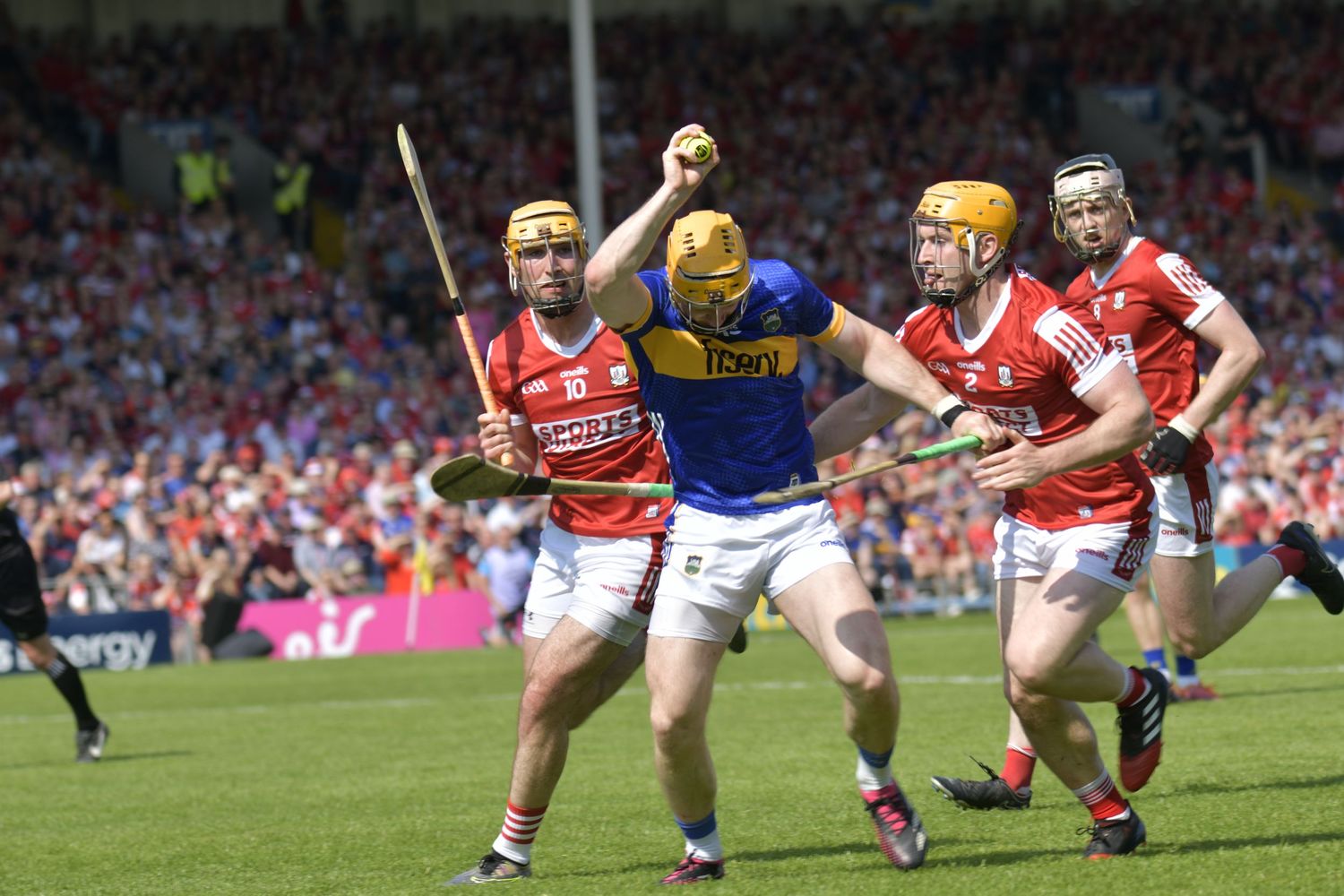 Action shot of hurling match with players competing intensely for the ball.