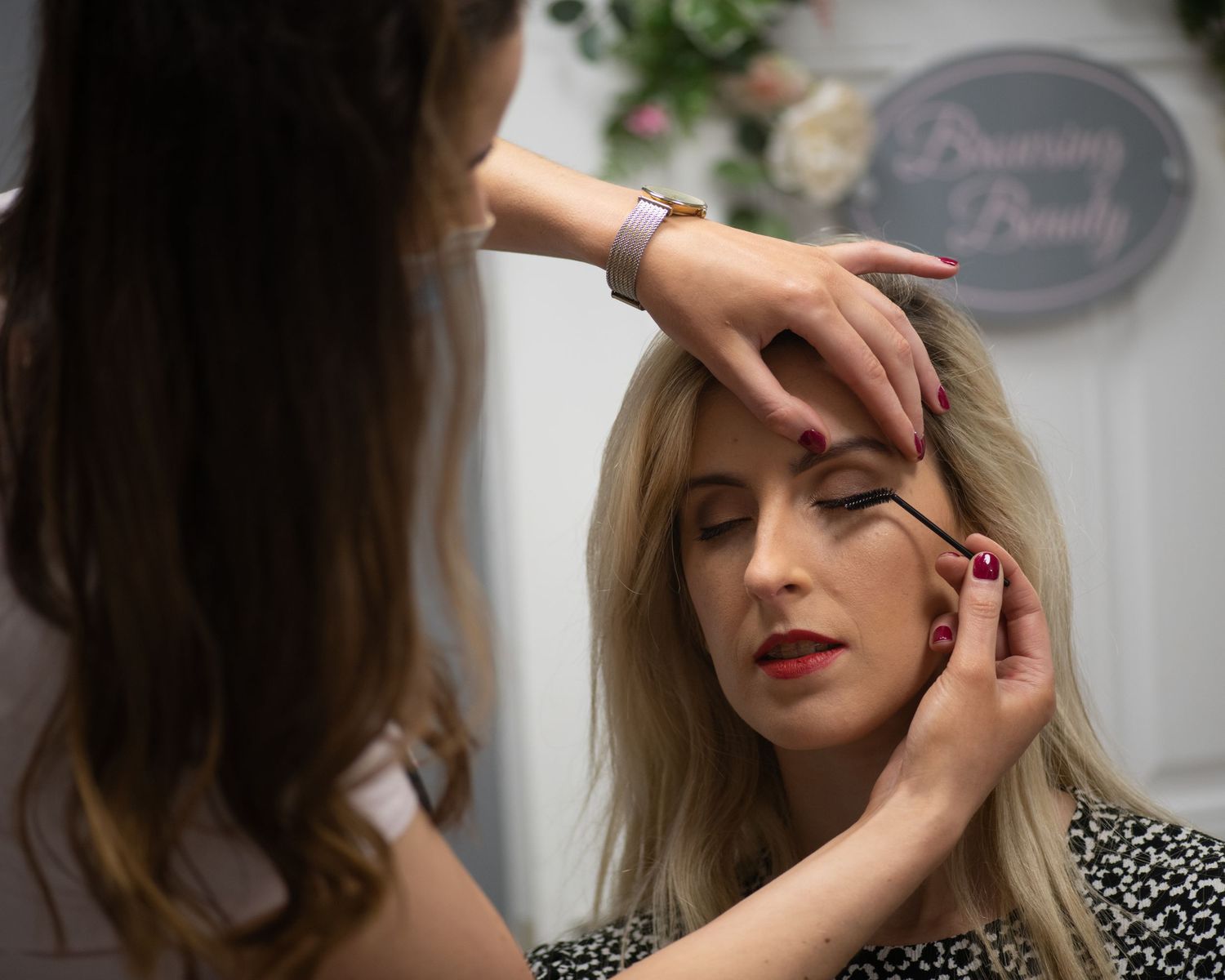 Professional makeup artist applying cosmetics during a beauty photoshoot session.