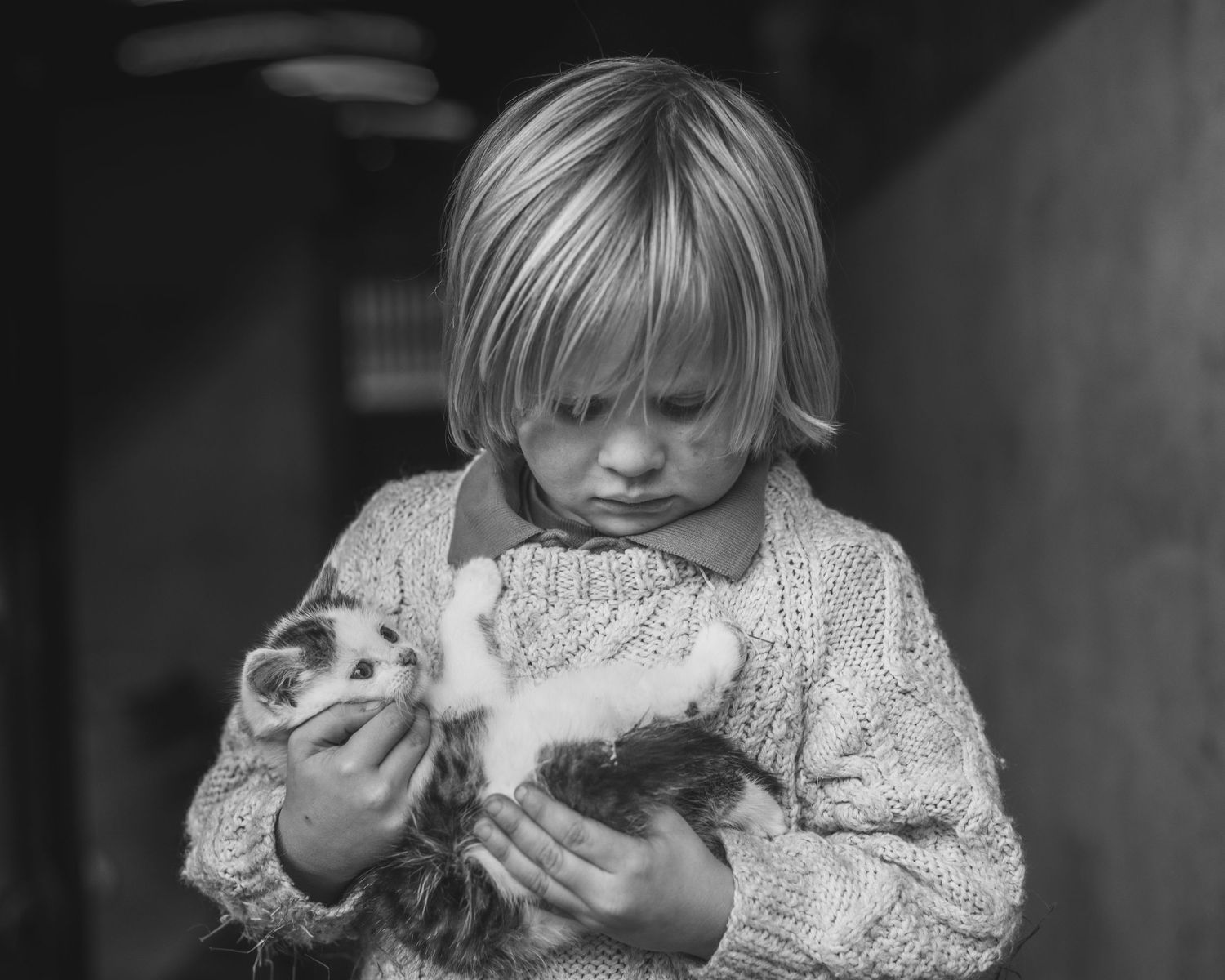 Black and white vintage photograph of a small child holding a fluffy rabbit.