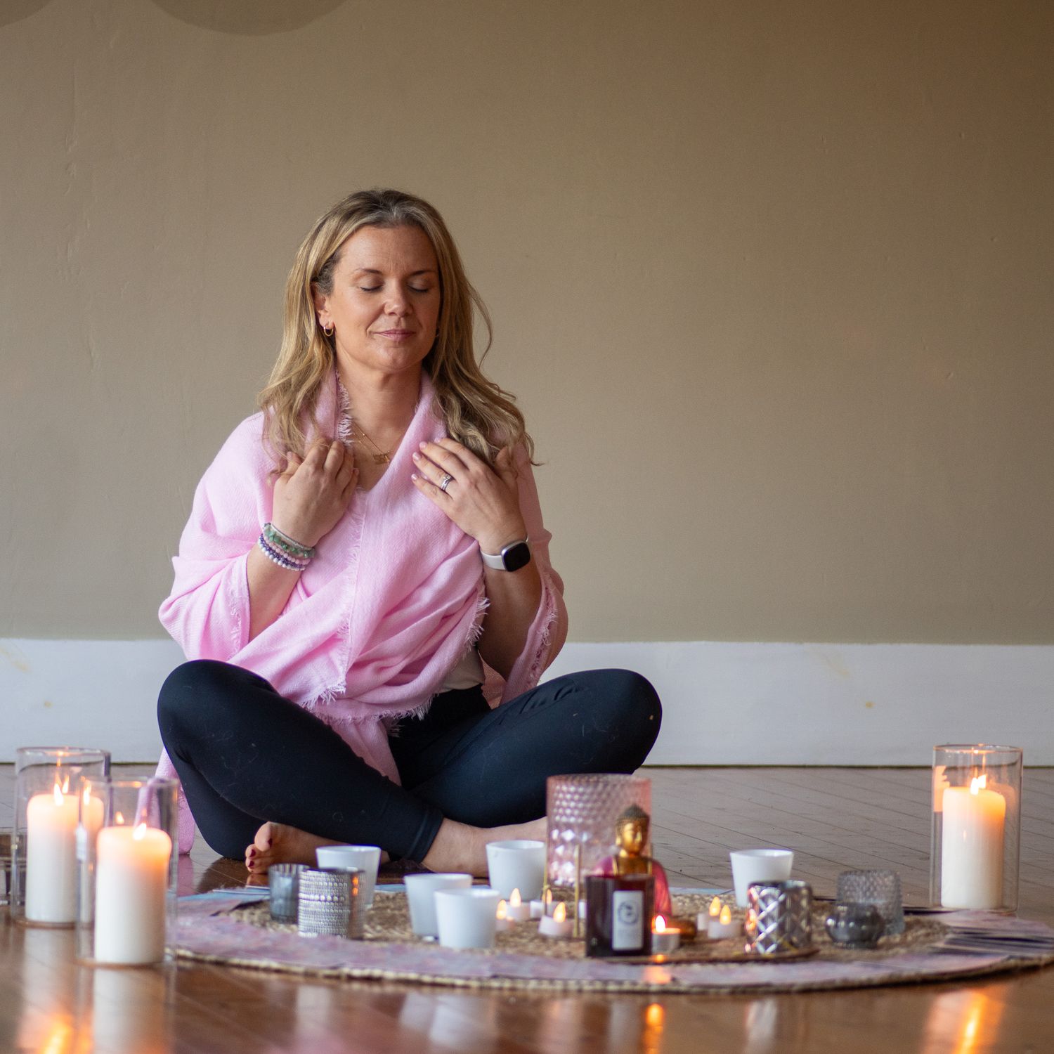 Candlelit scene with tea cups and cozy lighting arranged on wooden floor.