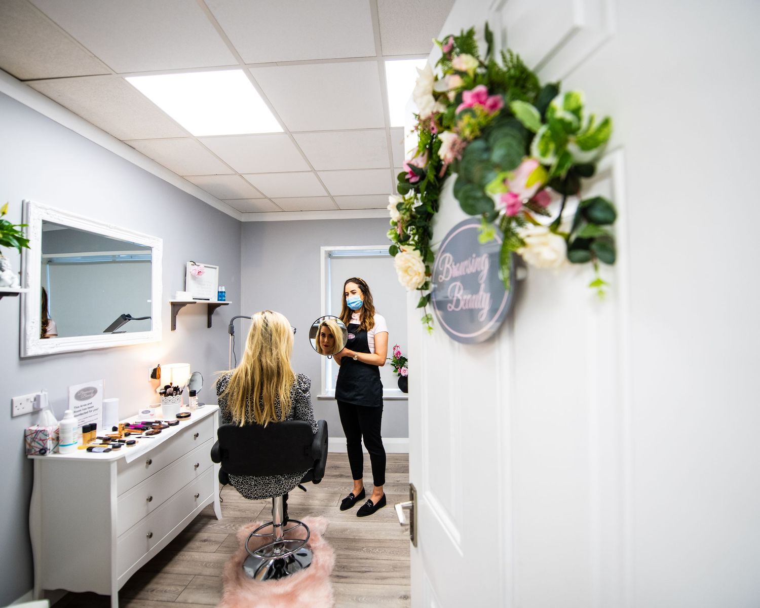 Interior view of modern salon with floral decor and white furnishings.