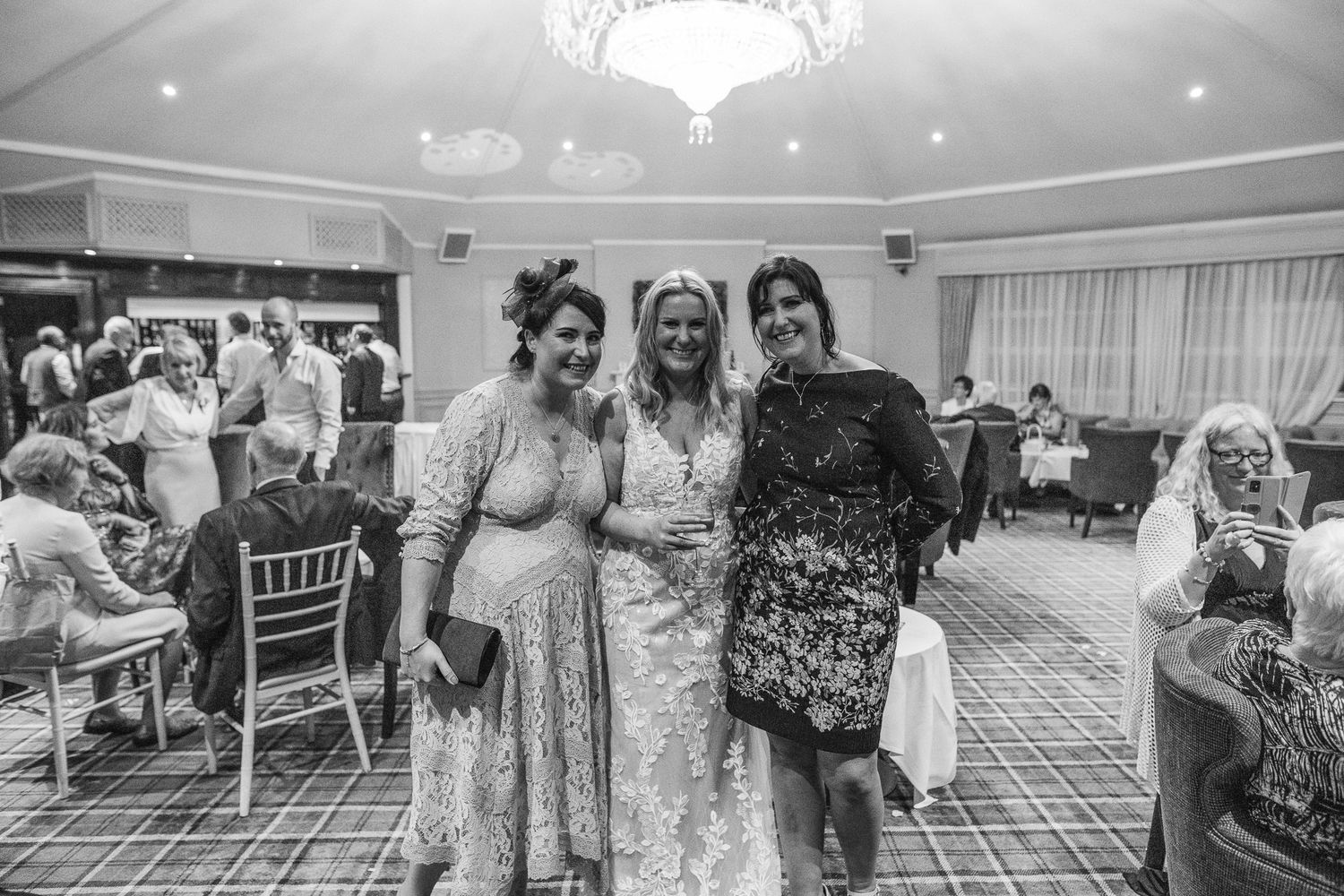 Wedding party members pose together in formal attire at an elegant reception venue.