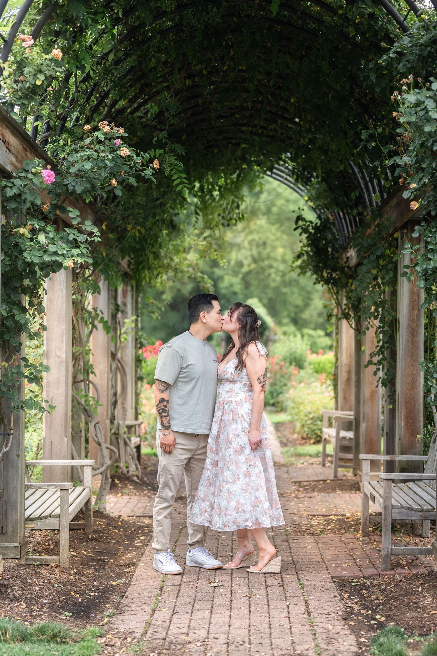 Couple romantic moments while walking together beneath a garden pergola covered in climbing vines. engagement Taylor Swift Travis Kelce