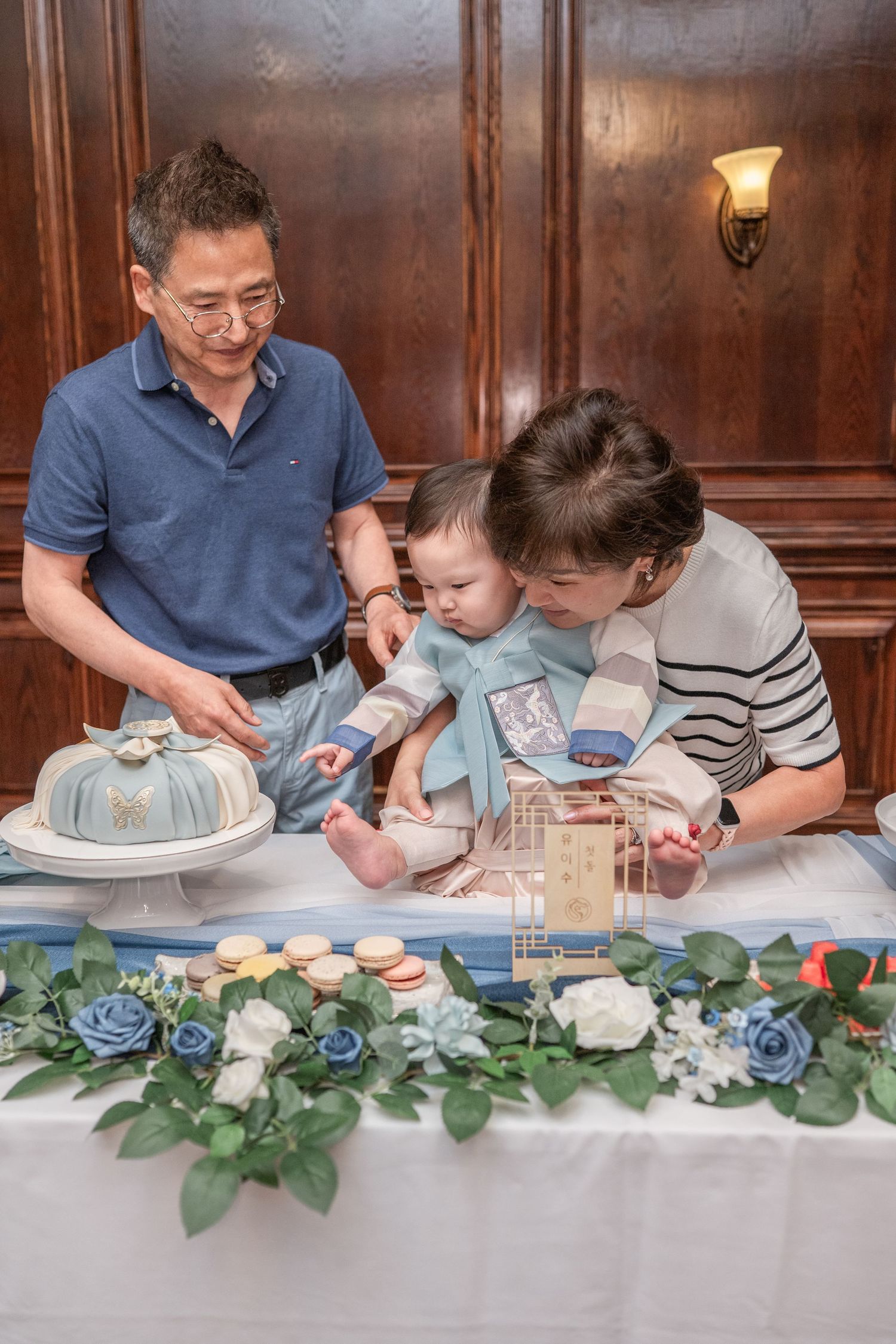 Family gathering around a decorated table with blue and white floral arrangements.