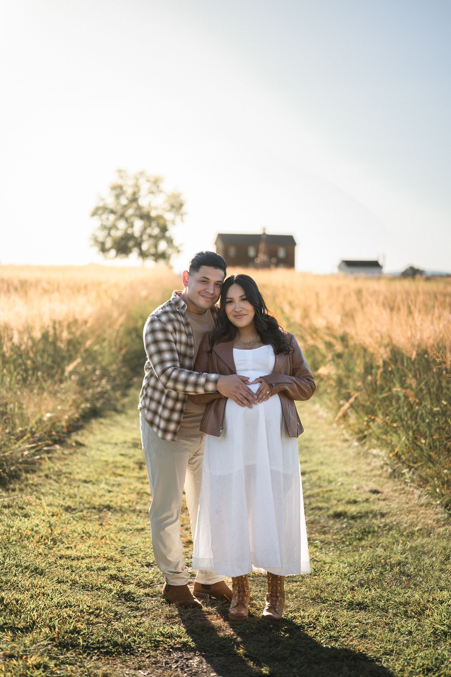 Three photos showing a loving family portrait session at golden hour in a sun-lit grassy field.