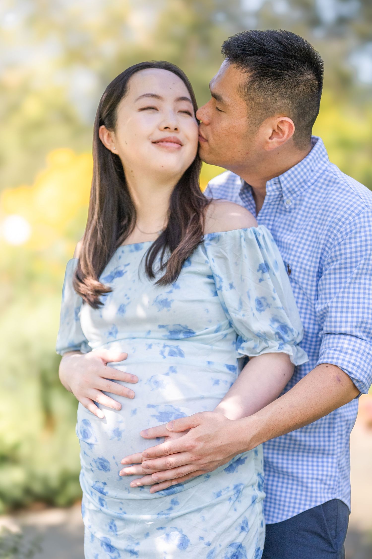 A couple shares tender moments in nature while wearing coordinating blue and white outfits during a photo session. Virginia photographer