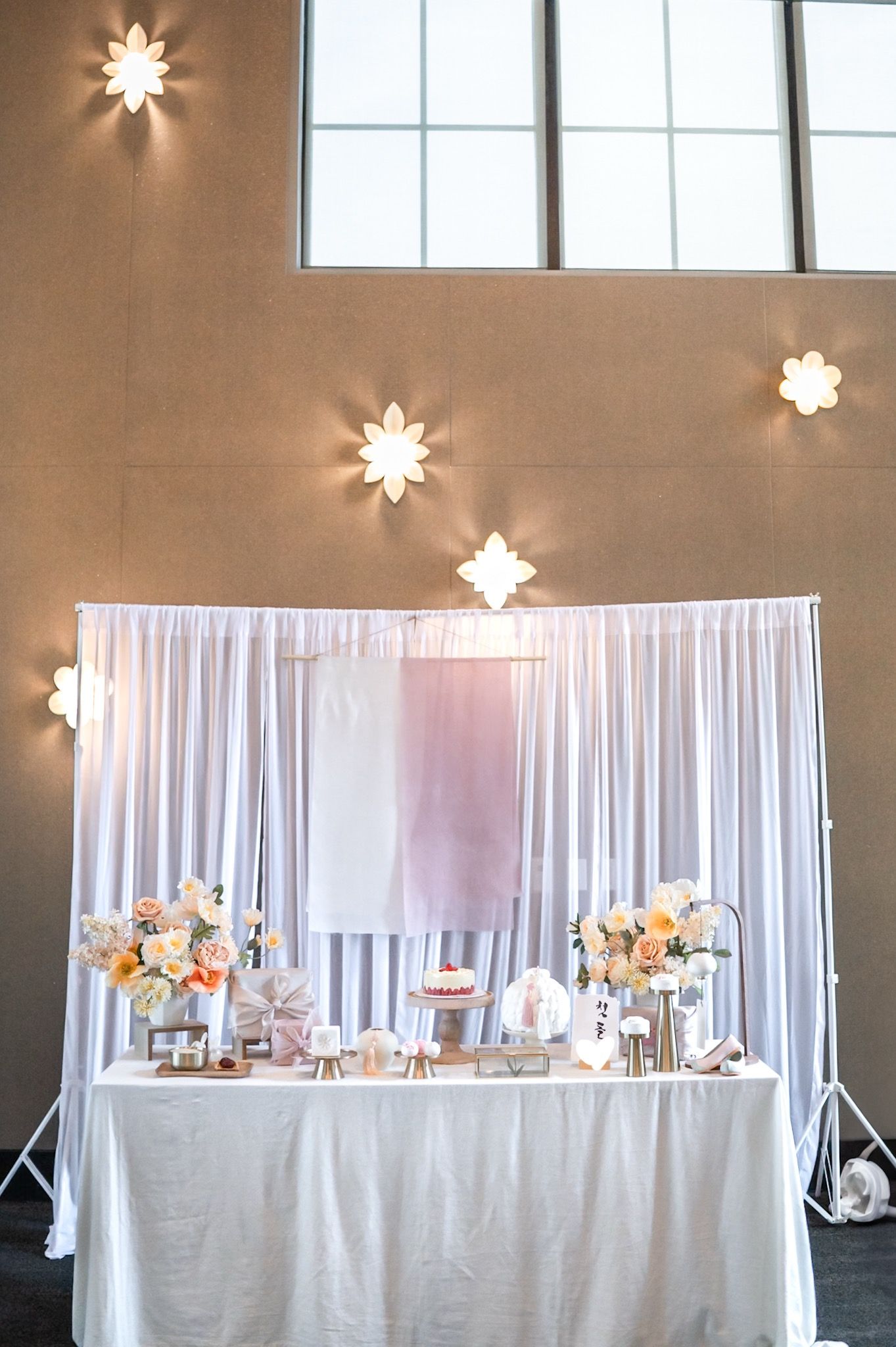 Elegant dohl reception table with white draping backdrop and star-shaped wall lights creating romantic ambiance. Alexandria photographer