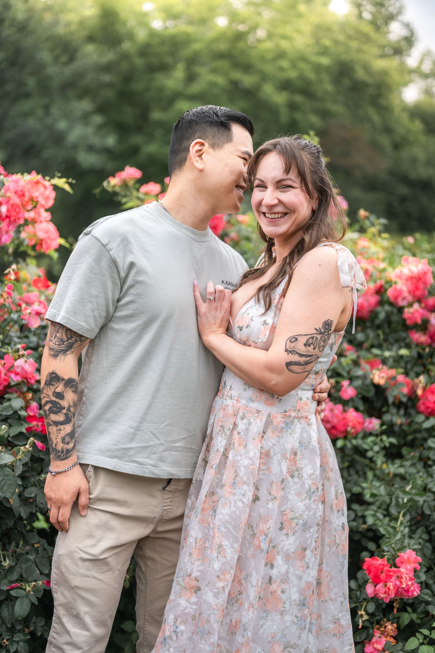 A tender moment shared between a couple embracing in a rose garden with pink flowers. NOVA Family Photographer