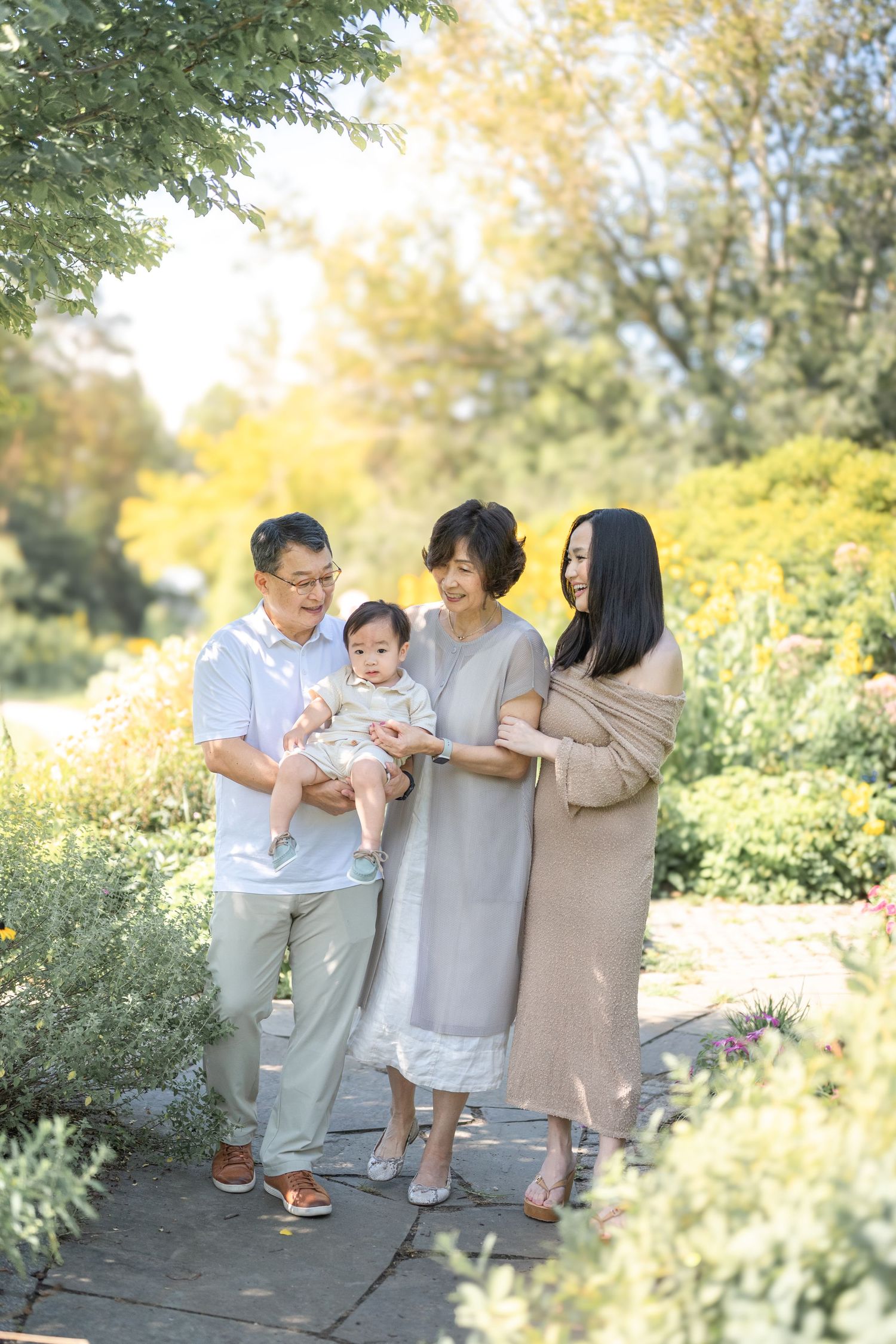A family gathers outdoors in light neutral clothing while enjoying a sunny autumn day in a natural setting. Arlington photographer