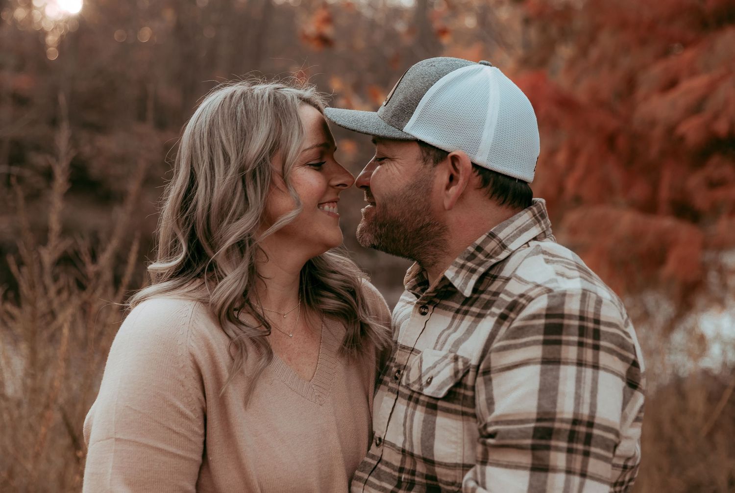Romantic couple sharing a tender moment outdoors in a beautiful autumn setting.