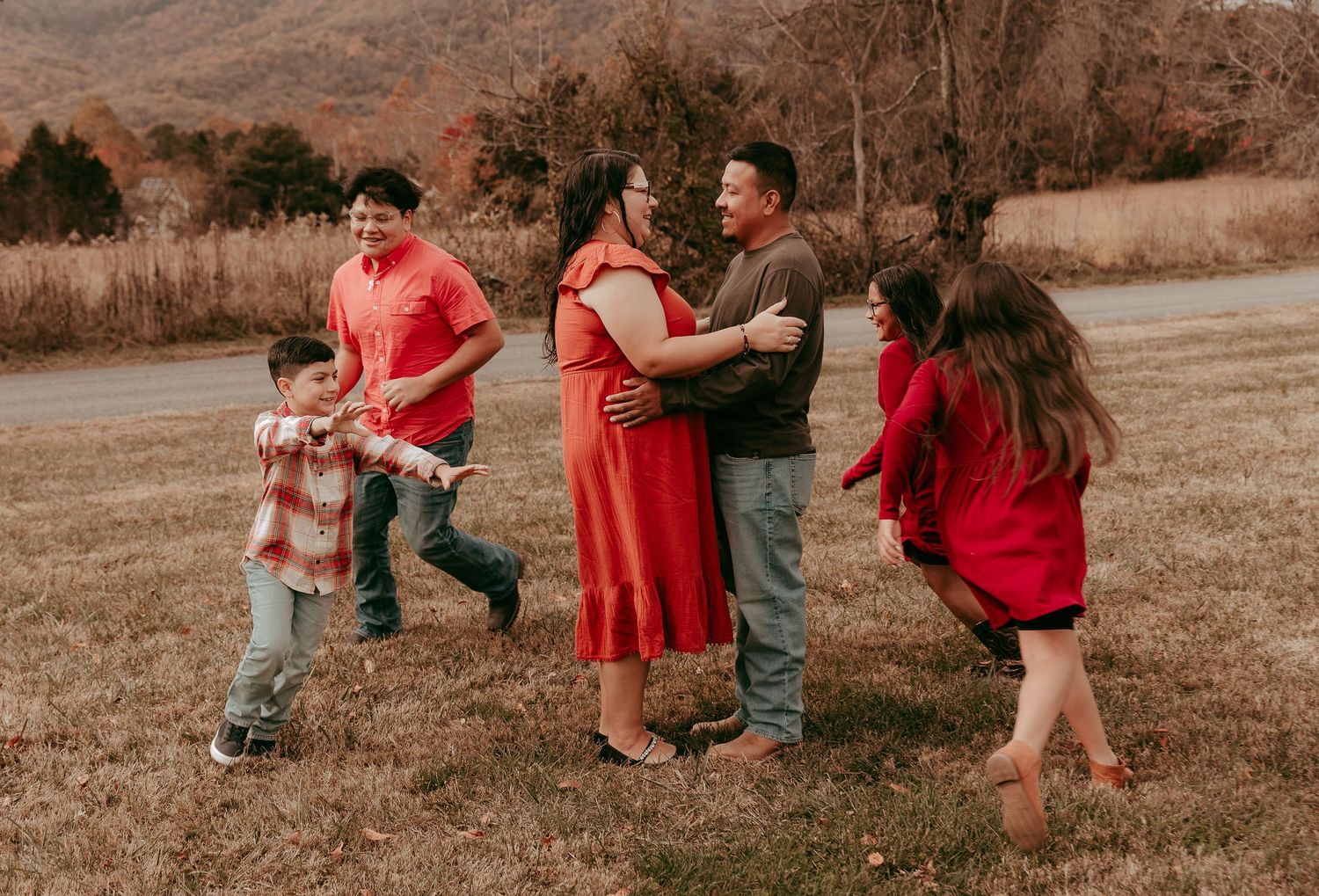 Lively family enjoying a candid outdoor moment together in a beautiful fall landscape.