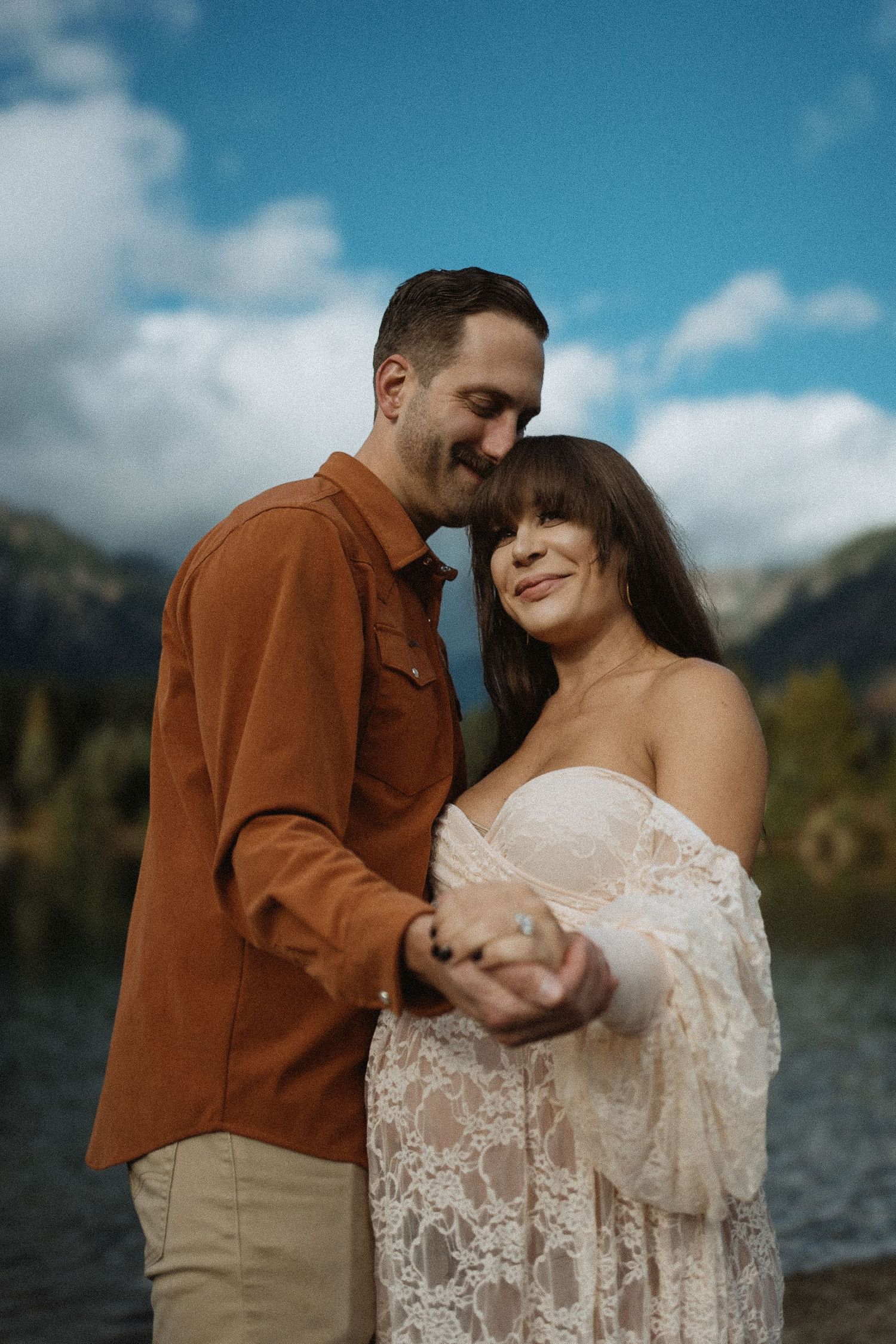 Maternity couple portrait at Gold Creek Pond in Seattle, cinematic 35mm film photography with vibrant sky and warm autumn tones