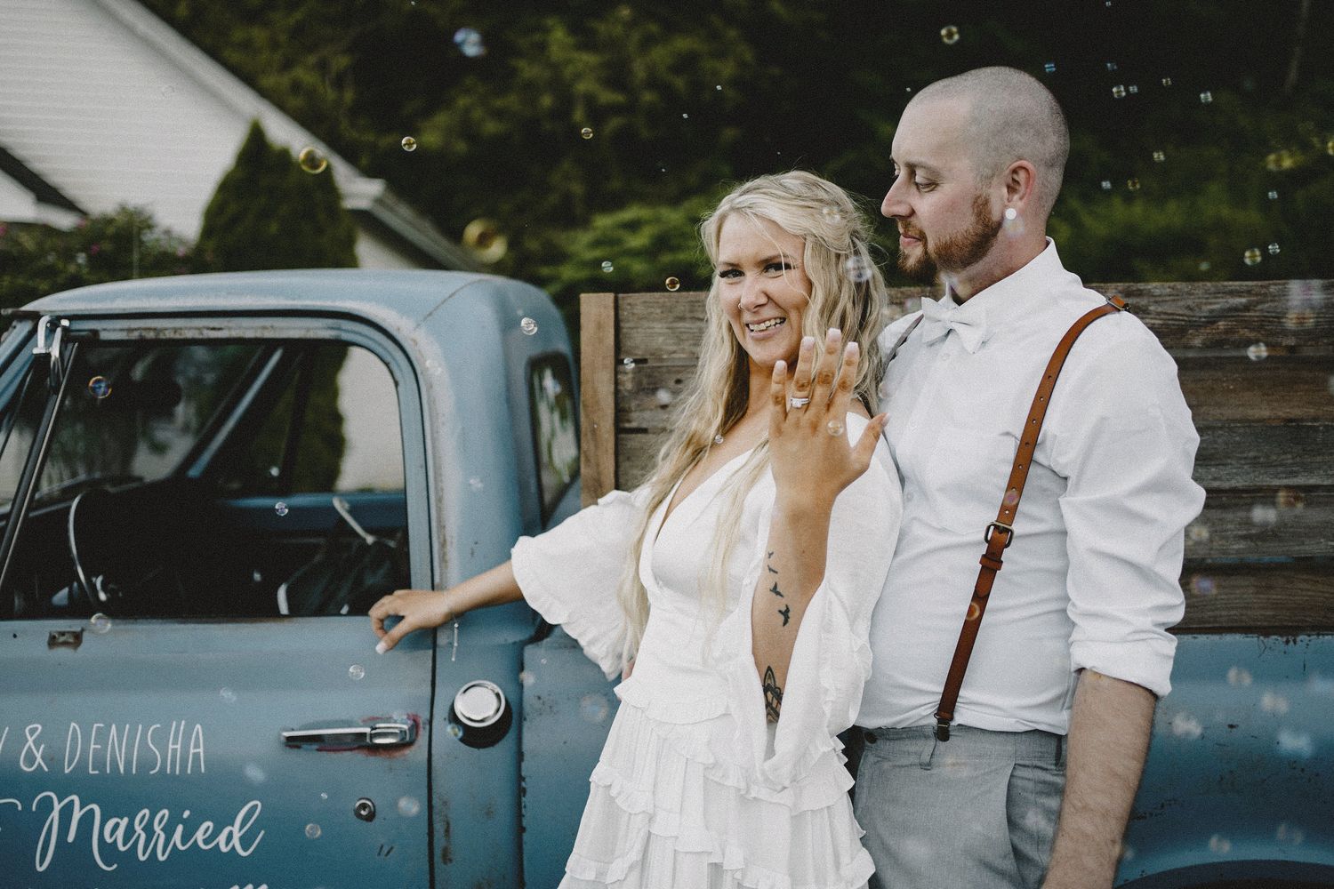 Vintage truck wedding portrait with bride and groom in rustic attire, cinematic film-inspired photography with natural light