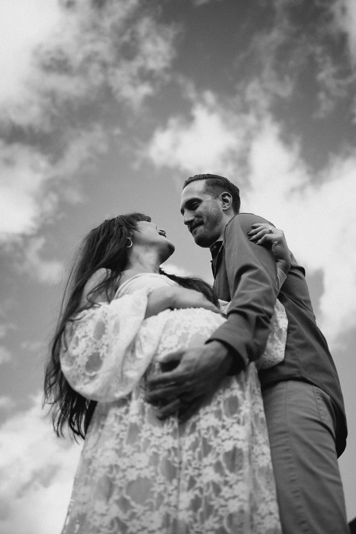 Black and white maternity portrait at Gold Creek Pond, artistic 35mm film approach showing intimate connection between expectant parents