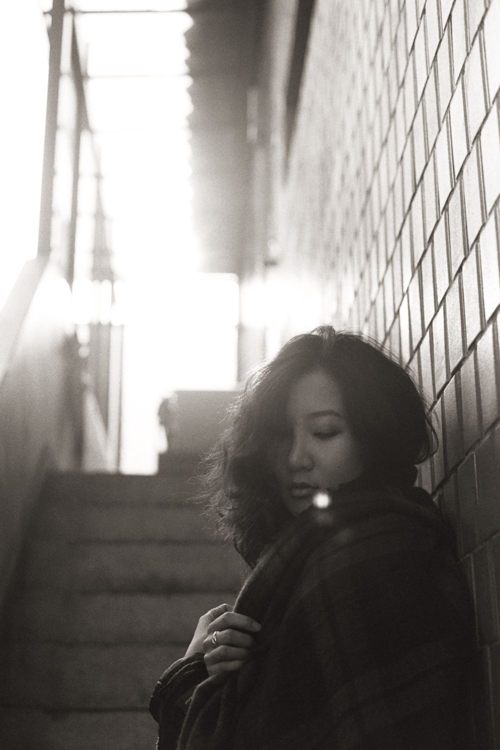 Moody black and white stairway portrait in Tulum, cinematic 35mm film photography with dramatic shadows and textured walls