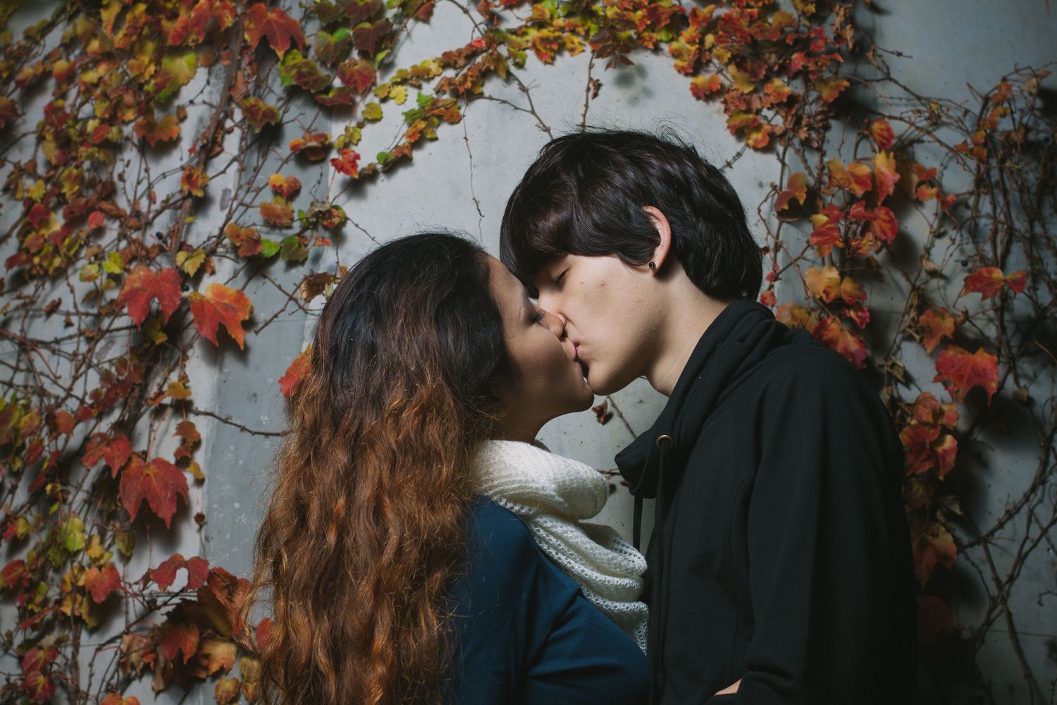 Intimate couple portrait framed by autumn foliage in Seoul, cinematic engagement photography with rich seasonal colors