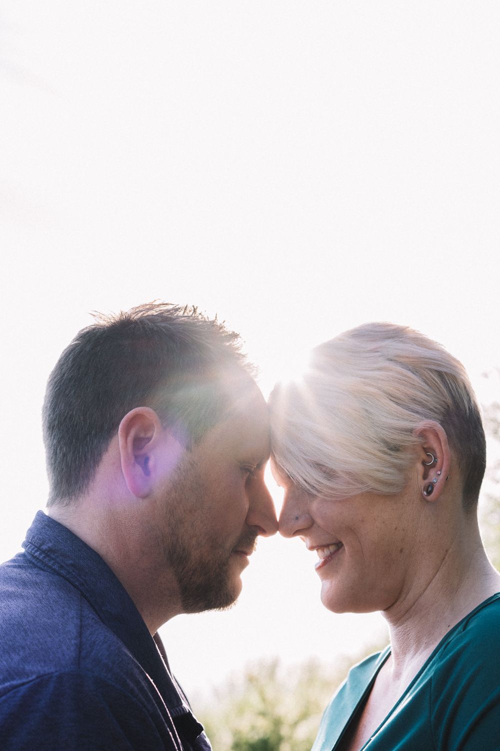 Intimate forehead touching moment at Richmond Beach in Seattle, engagement photography with soft backlighting