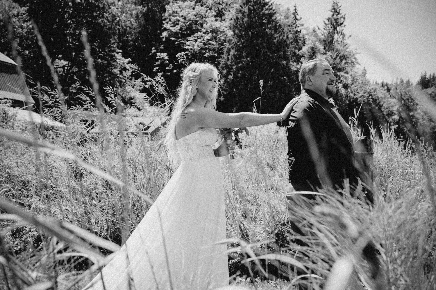 Black and white outdoor couple portrait in tall grass, cinematic wedding photography with natural light in Seattle landscape