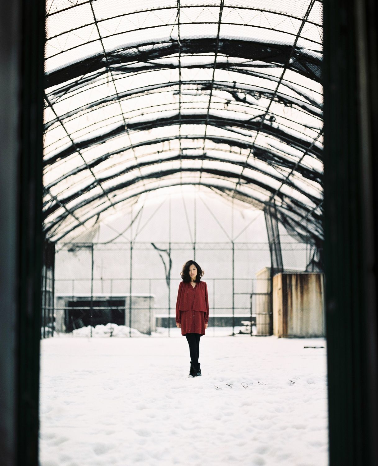 Architectural portrait in abandoned building Seoul with symmetrical arches, cinematic 35mm film photography with dramatic perspective
