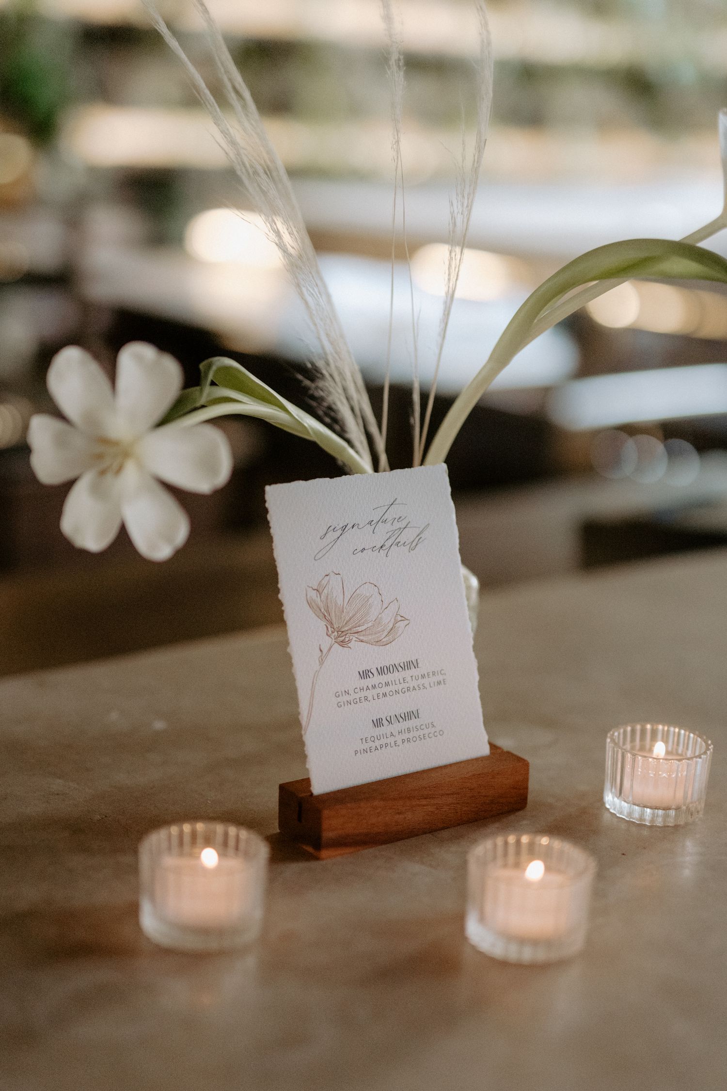 Elegant wedding cocktail menu with floral accents and candlelight at luxury Tulum destination wedding, showcasing intimate reception styling