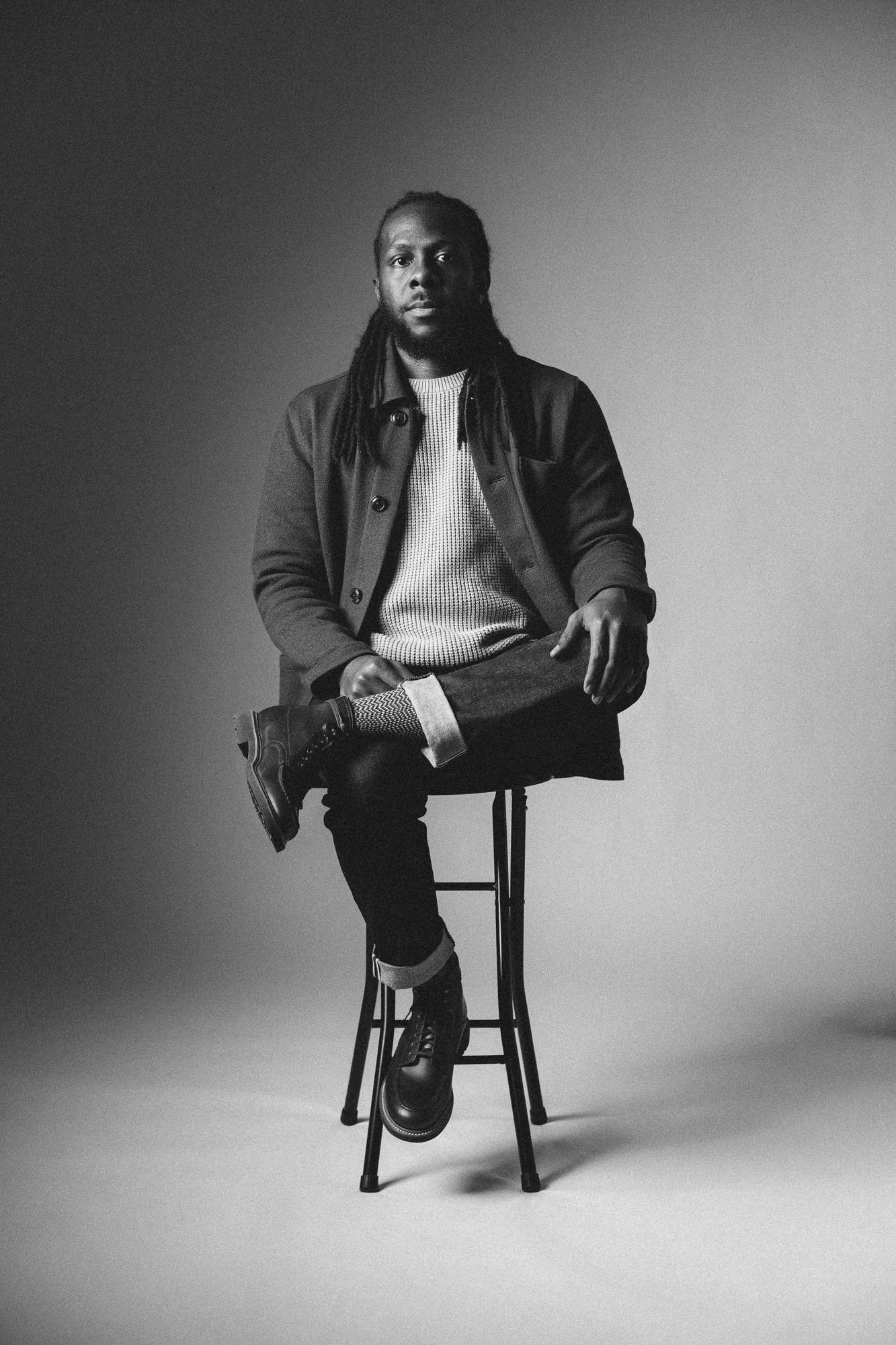 Black and white full-length studio portrait in Seattle, cinematic 35mm film photography with fashion-forward styling and minimal backdrop