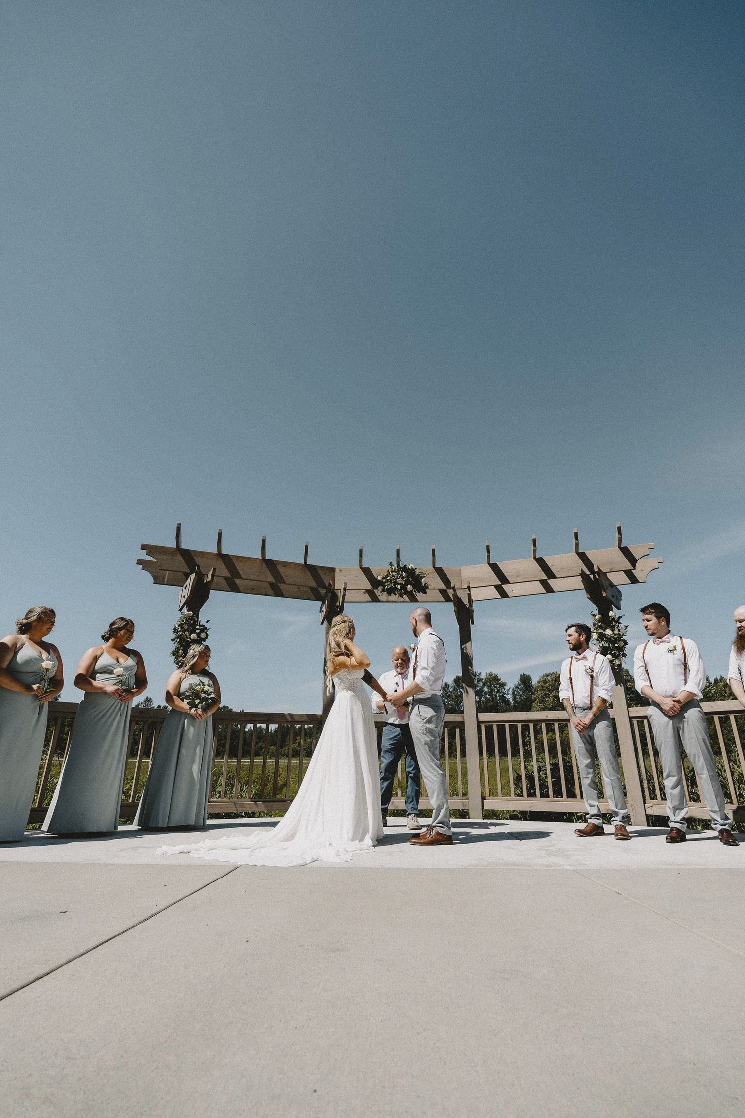 Outdoor ceremony setup with floral arch and blue sky, cinematic destination-inspired Seattle wedding photography with open vista