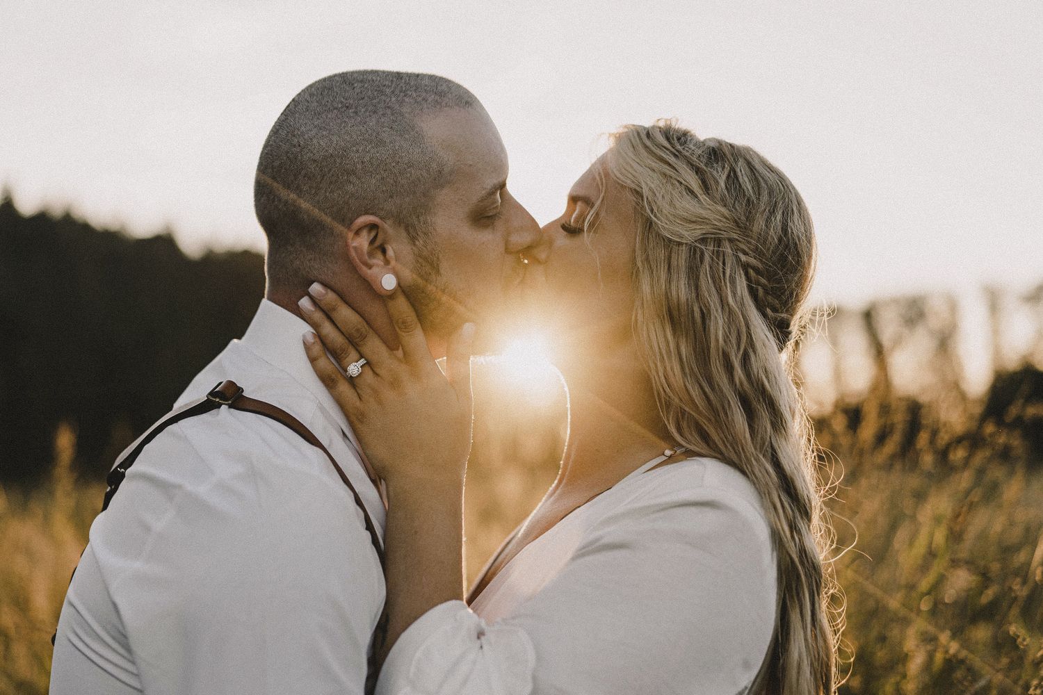 Golden hour kiss portrait with sunlight between couple, cinematic Seattle wedding photography of bride and groom with warm dramatic lighting