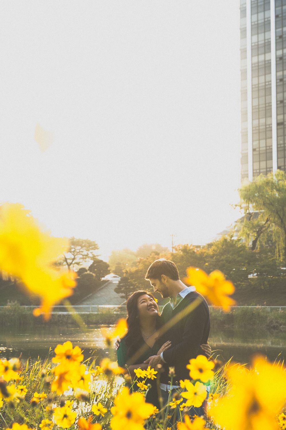 Spring engagement portrait with yellow flowers in Seoul, bright natural light photography capturing candid couple moment