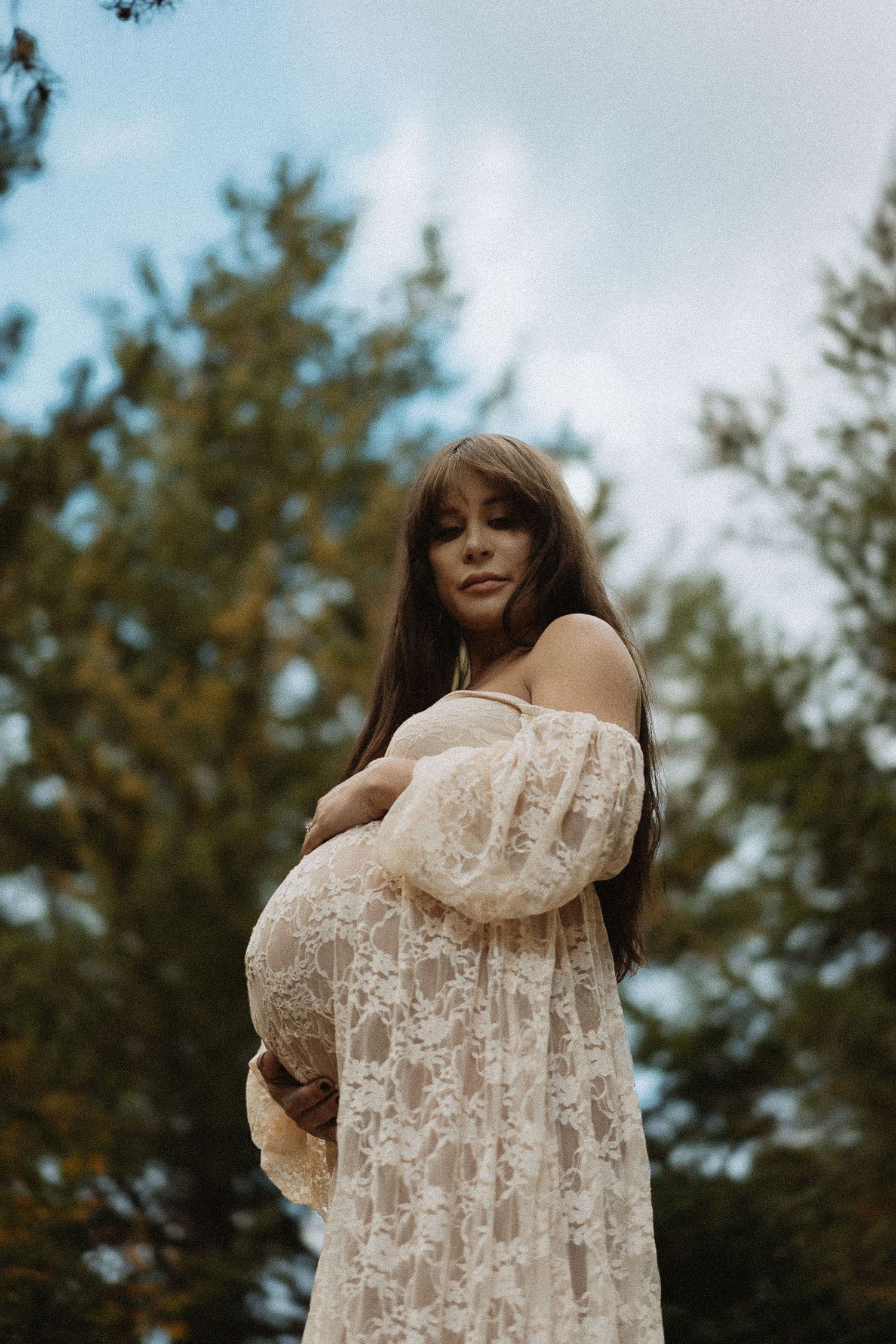 Maternity portrait at Gold Creek Pond in Seattle, natural light photography with forest backdrop and flowing dress
