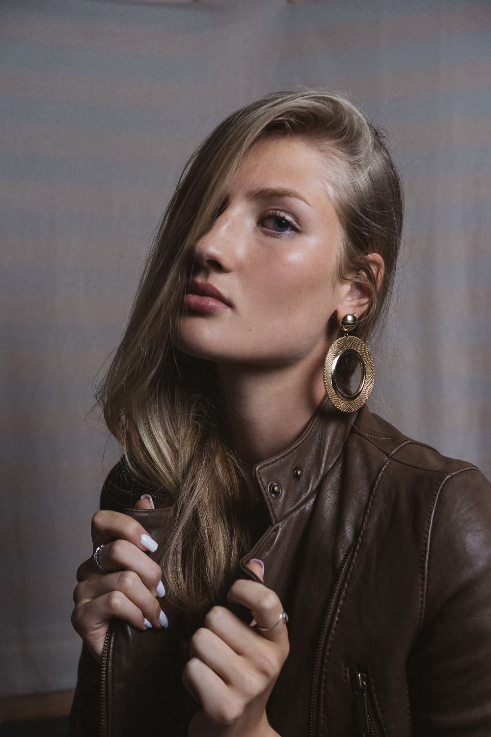 Studio portrait with moody lighting and leather jacket, Seattle cinematic film photography with editorial fashion aesthetic