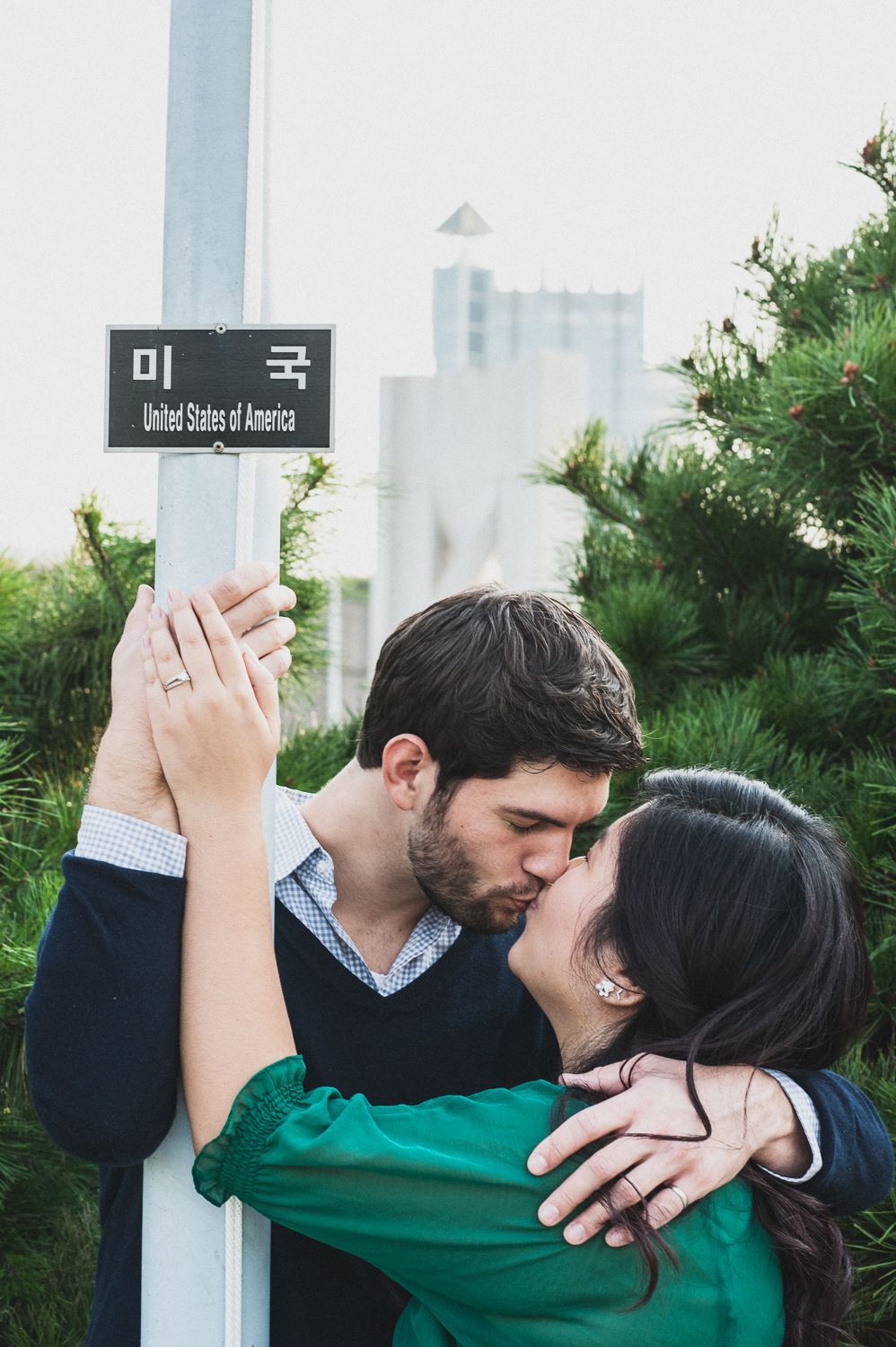 Urban Seoul engagement portrait with couple embracing, cinematic street photography with intimate documentary approach