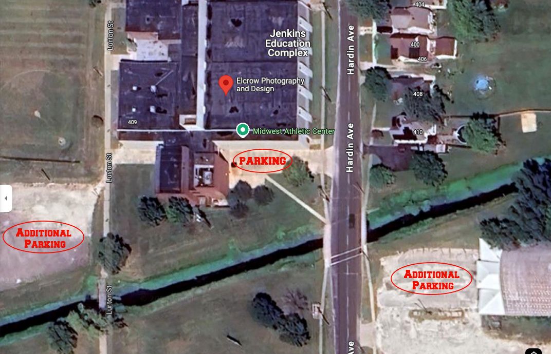 Aerial satellite view of commercial buildings and baseball fields along a road with visible properties and landscaping. Home of Elcrow Photo