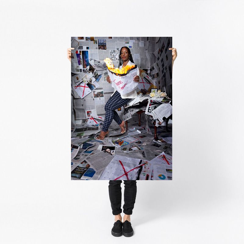 A person in casual attire sits suspended in mid-air surrounded by floating papers and documents in a studio setting.