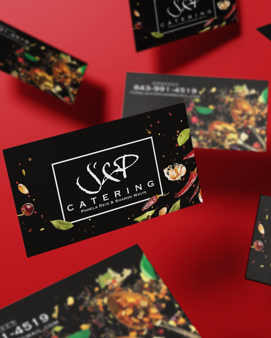 Black business cards for S&P Catering featuring floral design elements on red background. Portrava Creative Studios