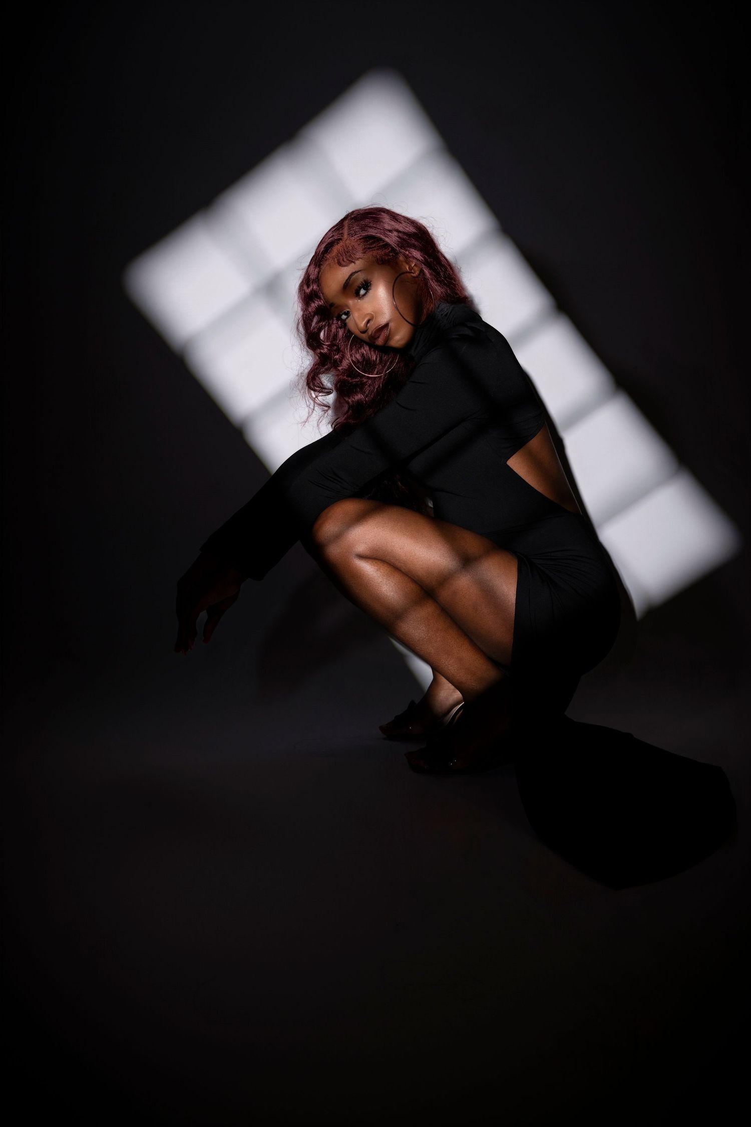 Dramatic fashion photo with white geometric background and dark clothing. Portrava Creative Studios