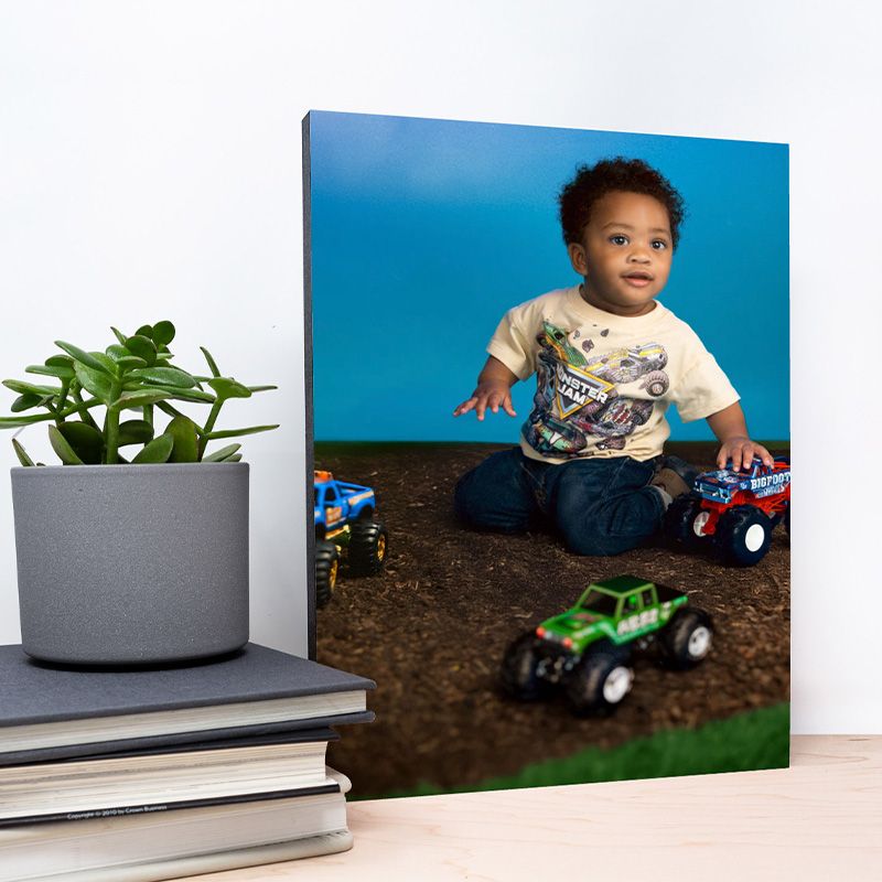 A series of photo prints showing a toy tractor in dirt against a blue background.