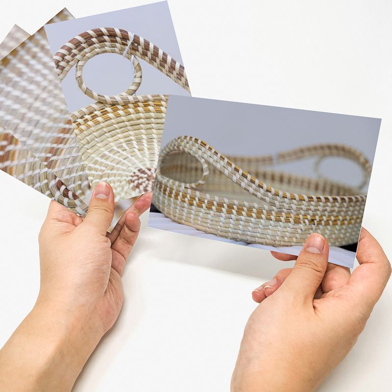 Hands arranging multiple pieces of transparent glass or acrylic sheets in a row.