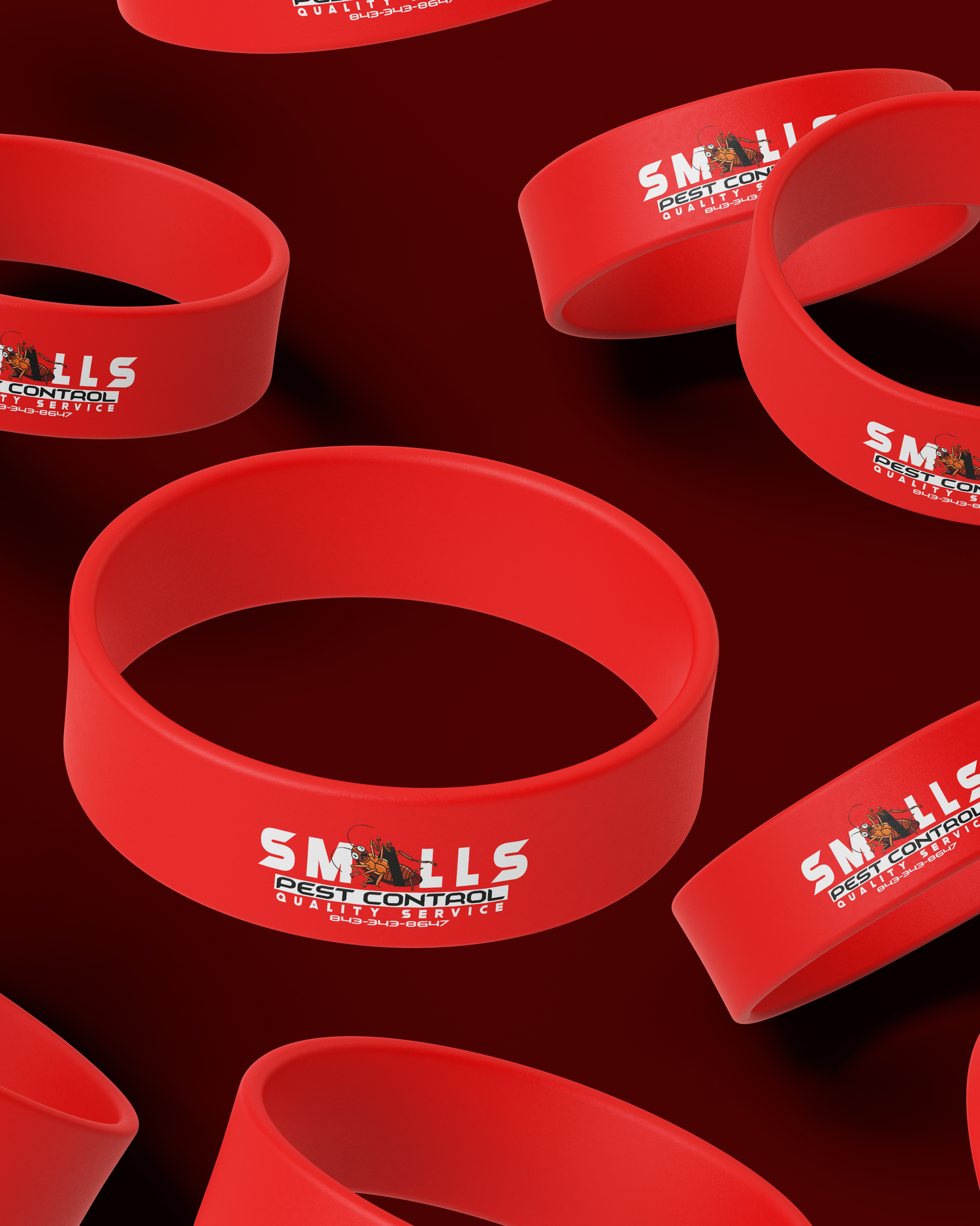 Red silicone wristbands with SMALLS logo arranged on dark background. Portrava Creative Studios
