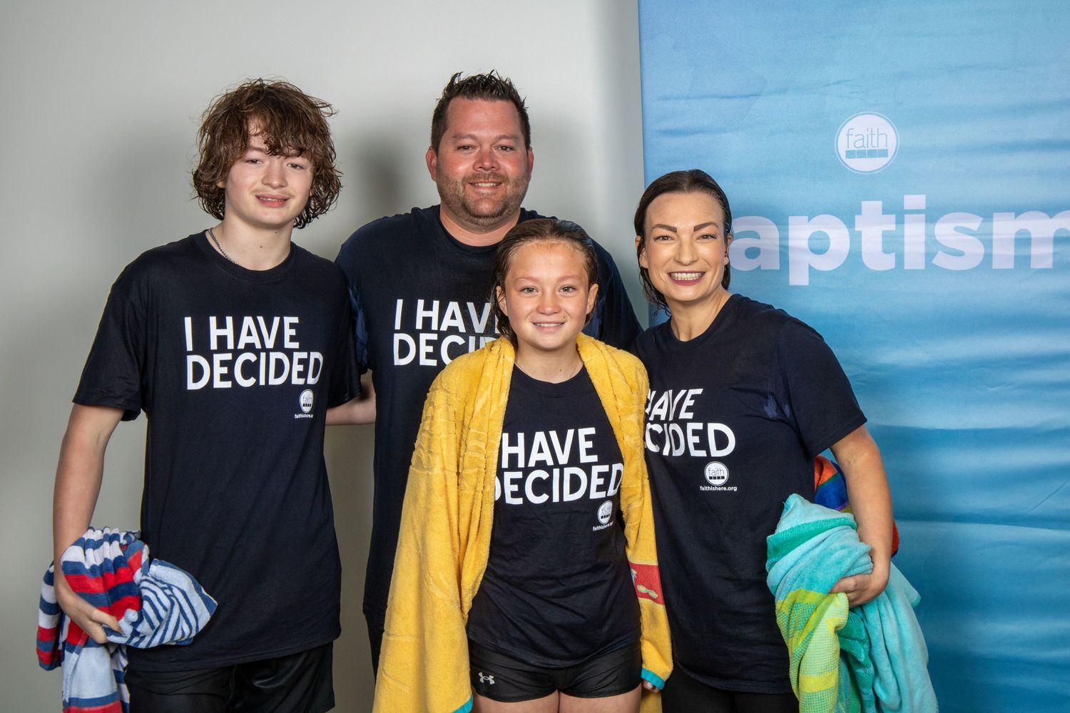Family group wearing matching 'I Have Decided' t-shirts poses together at baptism event. Portrava Creative Studios
