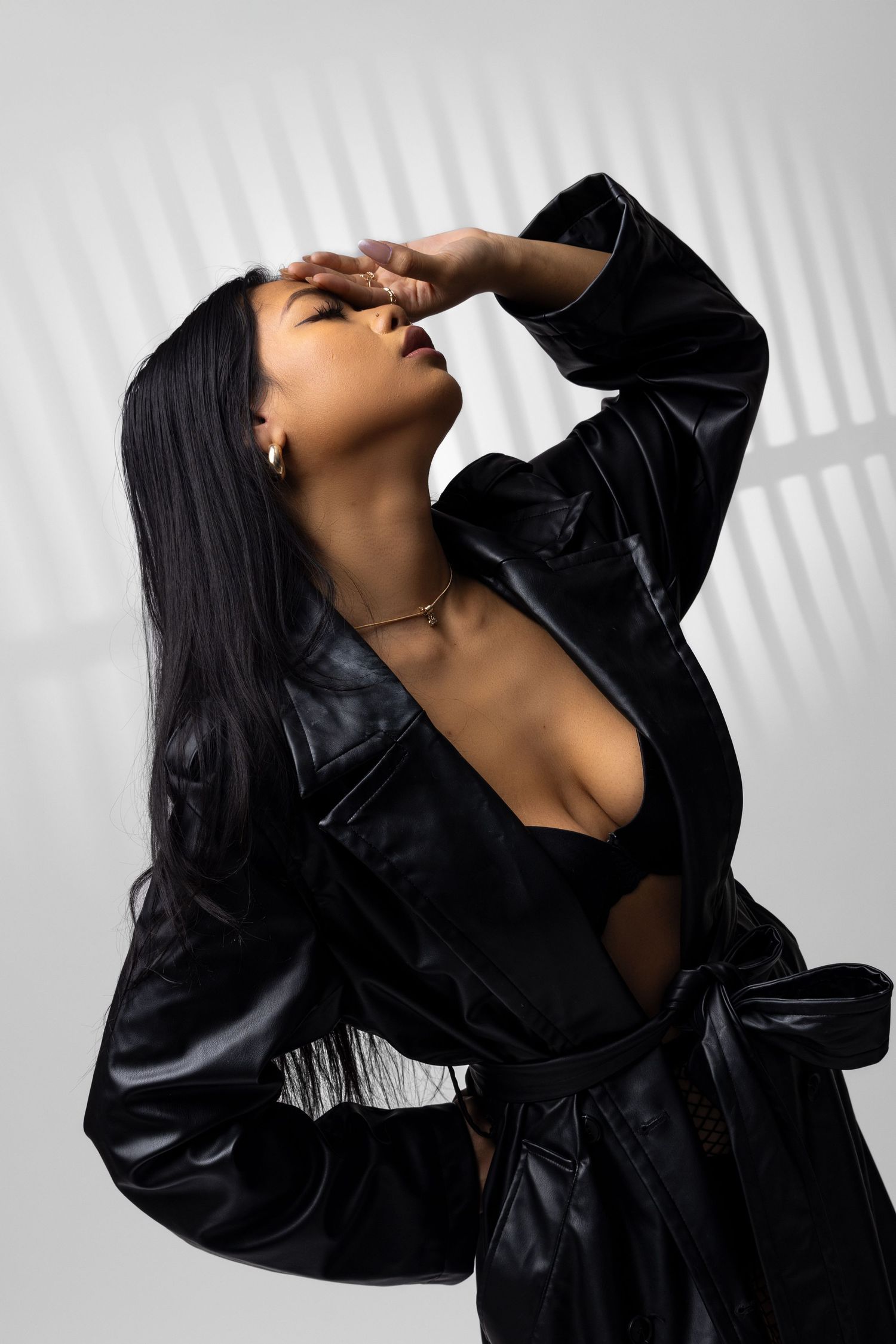 Artistic fashion portrait with black leather jacket and window shadow patterns. Portrava Creative Studios