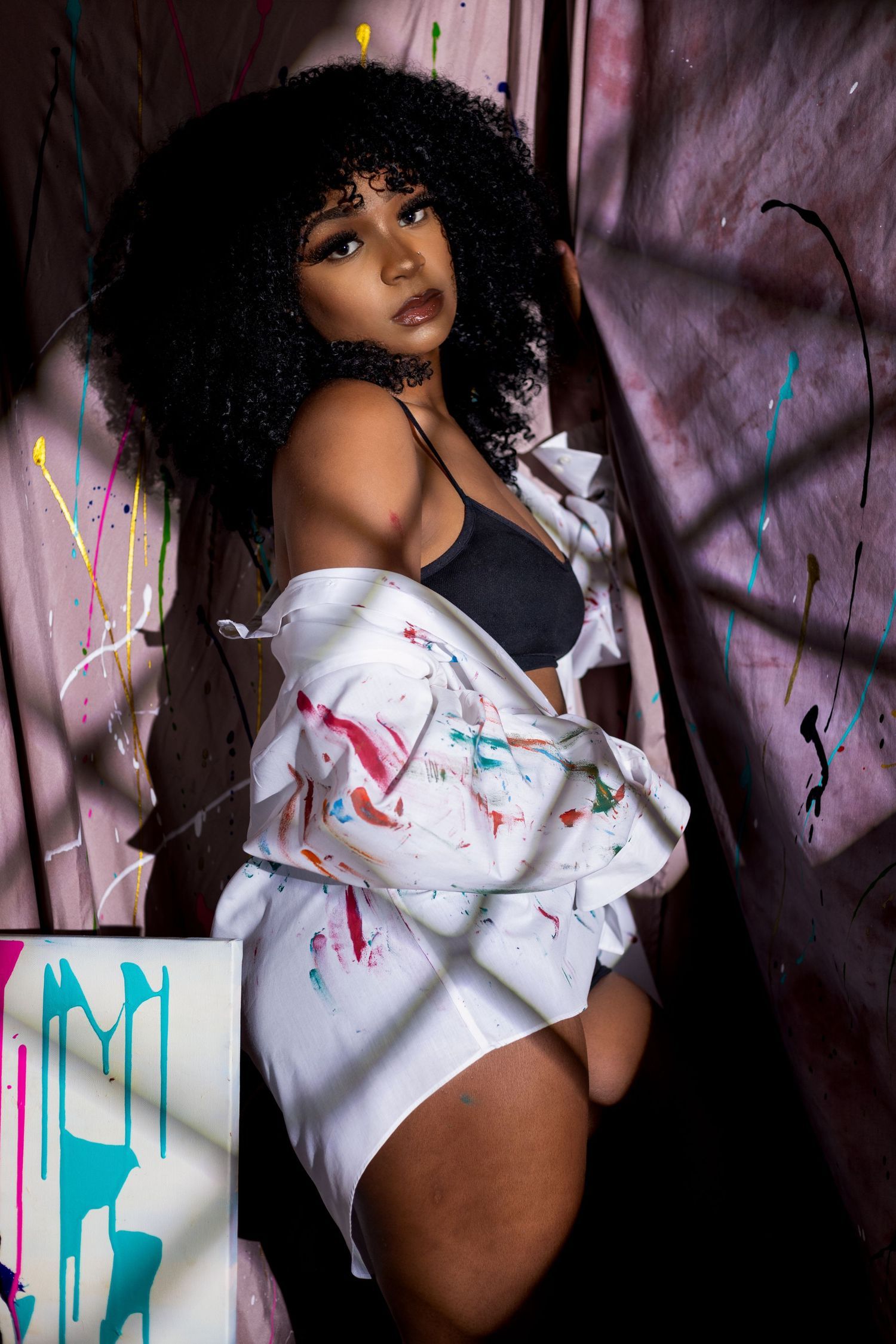 Intimate portrait featuring a white button-down shirt against colorful paint splatters. Portrava Creative Studios