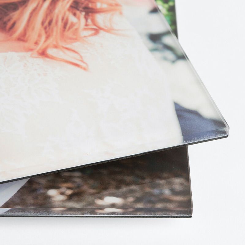 Close-up detail of photo prints stacked on top of each other showing paper texture and edges.